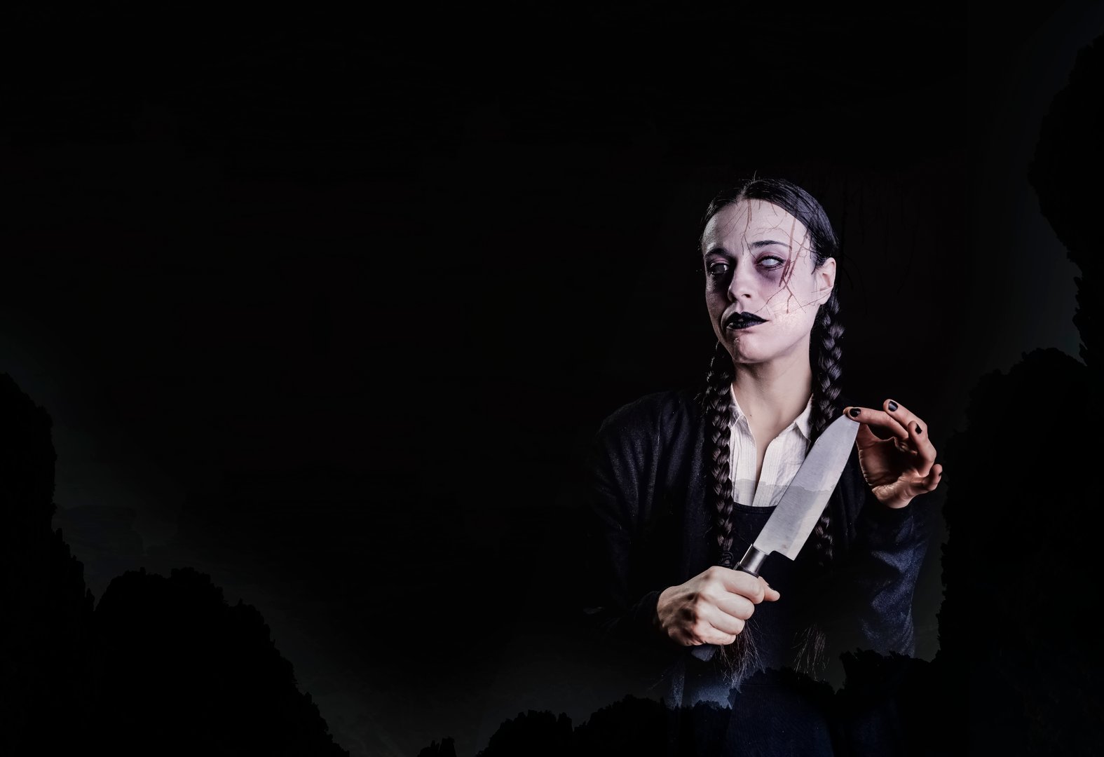 A woman with long braids, with gothic and dark look, plays with a butcher knife with her hand, in a spooky and spooky atmosphere, perfect for halloween
