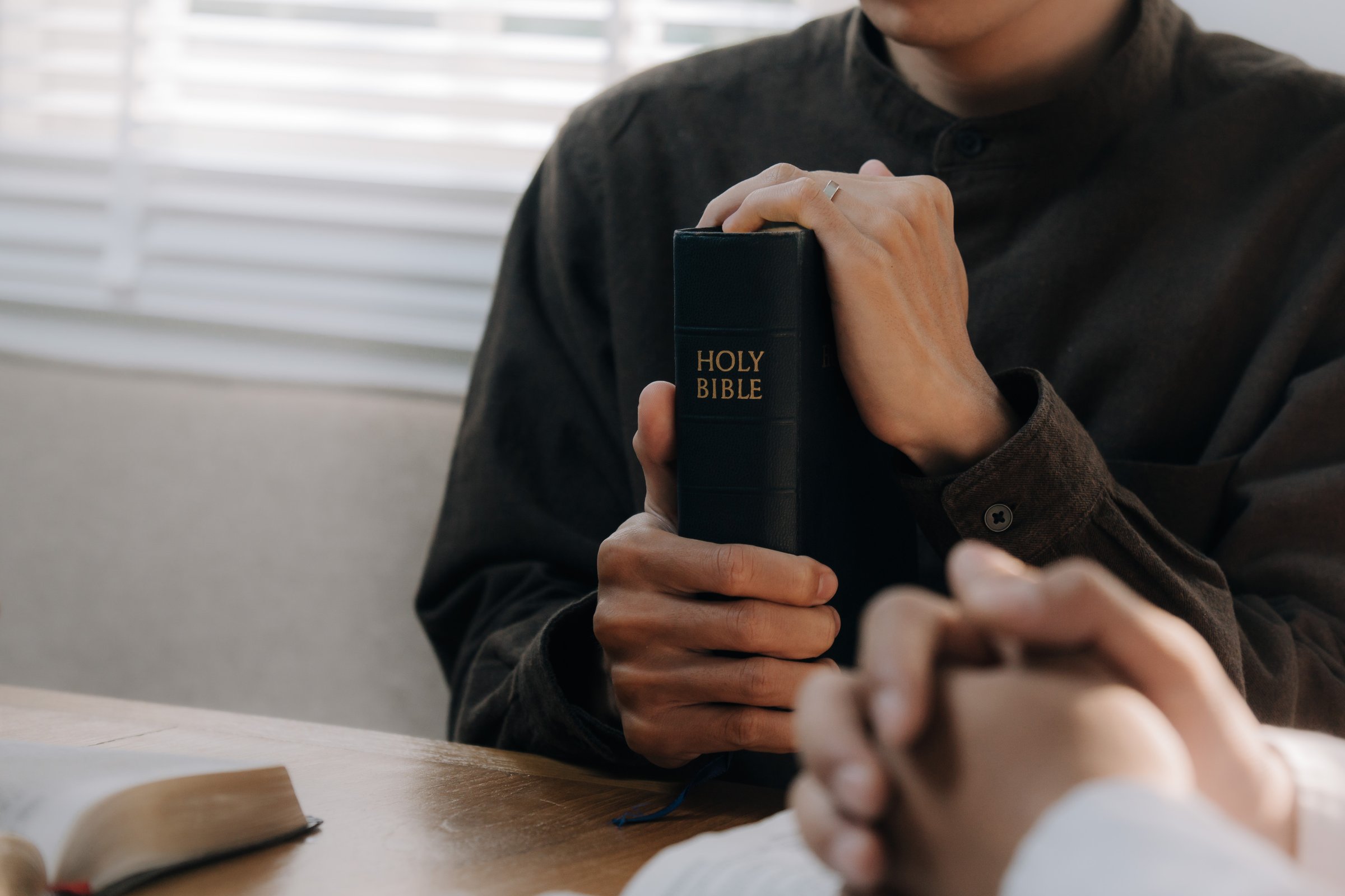 Christian man hands holding the holy bible to pray and worship God in the sunday morning.spirituality, religion,believe.Christian life.Studying the word of God in church.