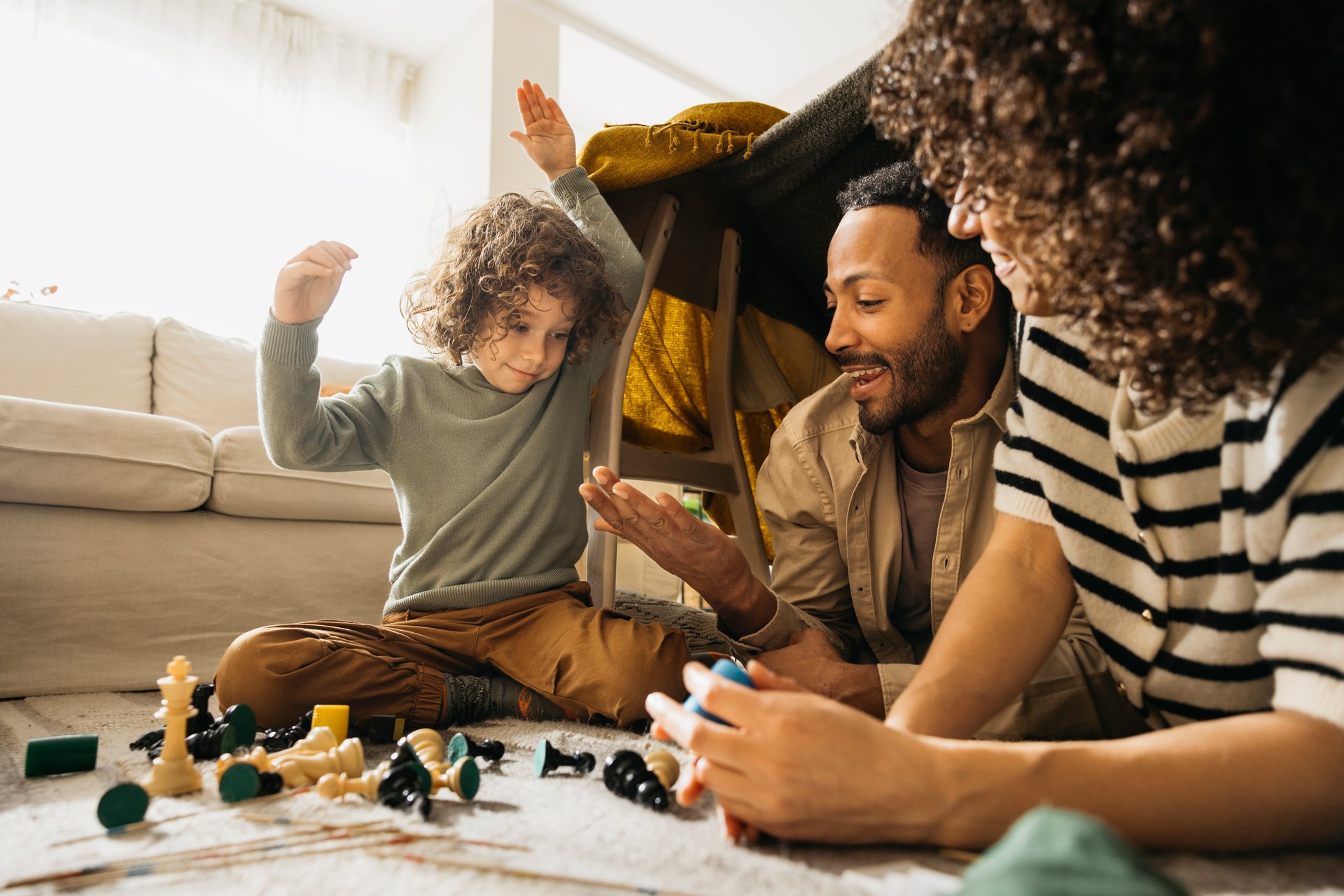 Two children playing together in cozy blanket fort at home