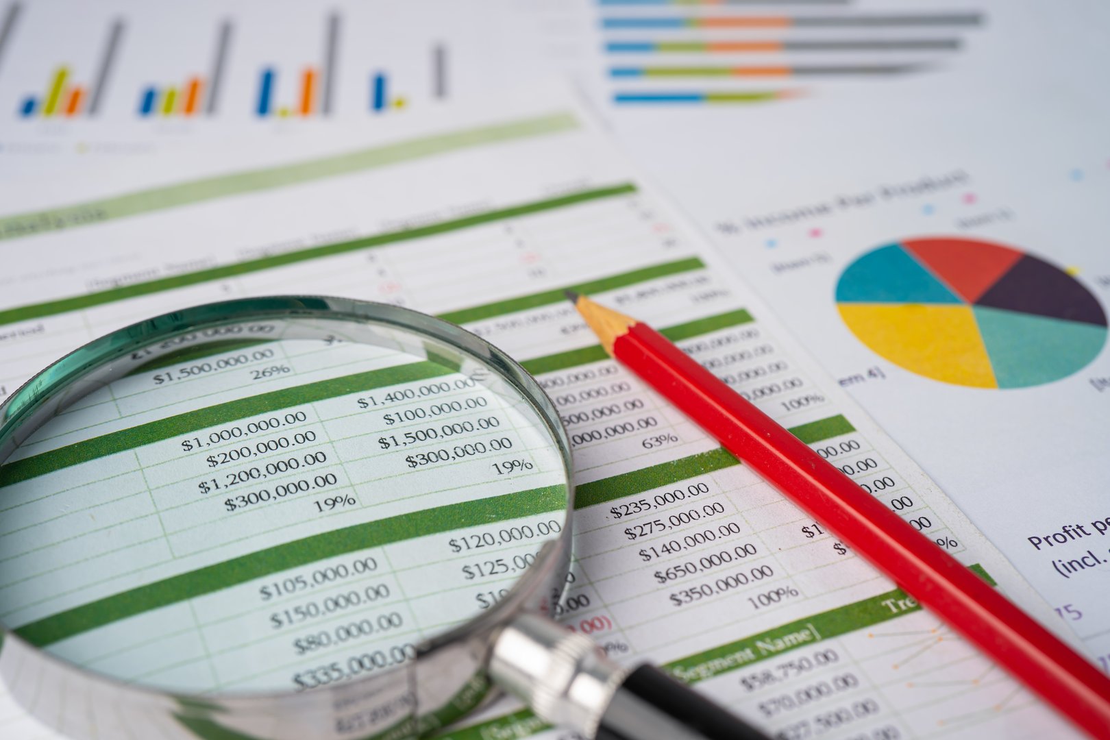 Magnifying glass with pencil on spreadsheet table and graph paper; Finance development, Banking Account, Statistics Investment Analytic research data economy, trading, Mobile office reporting Business company meeting concept.