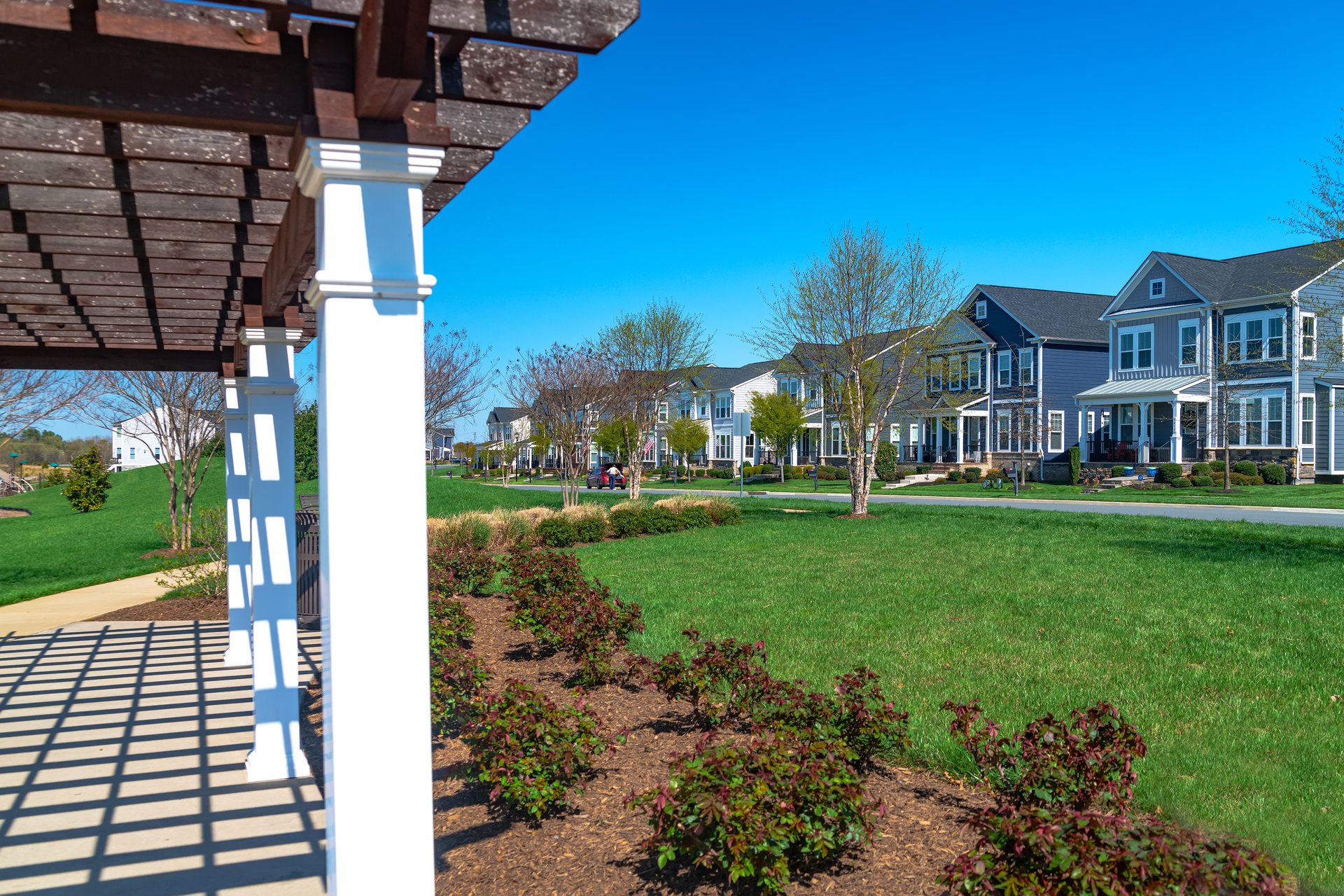 Modern homes along a road with a lawn and sidewalk. in a new residential community in Leesburg, Virginia.