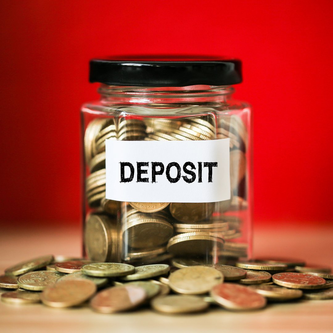 Deposit concept glass jar with a lot of coins inside.