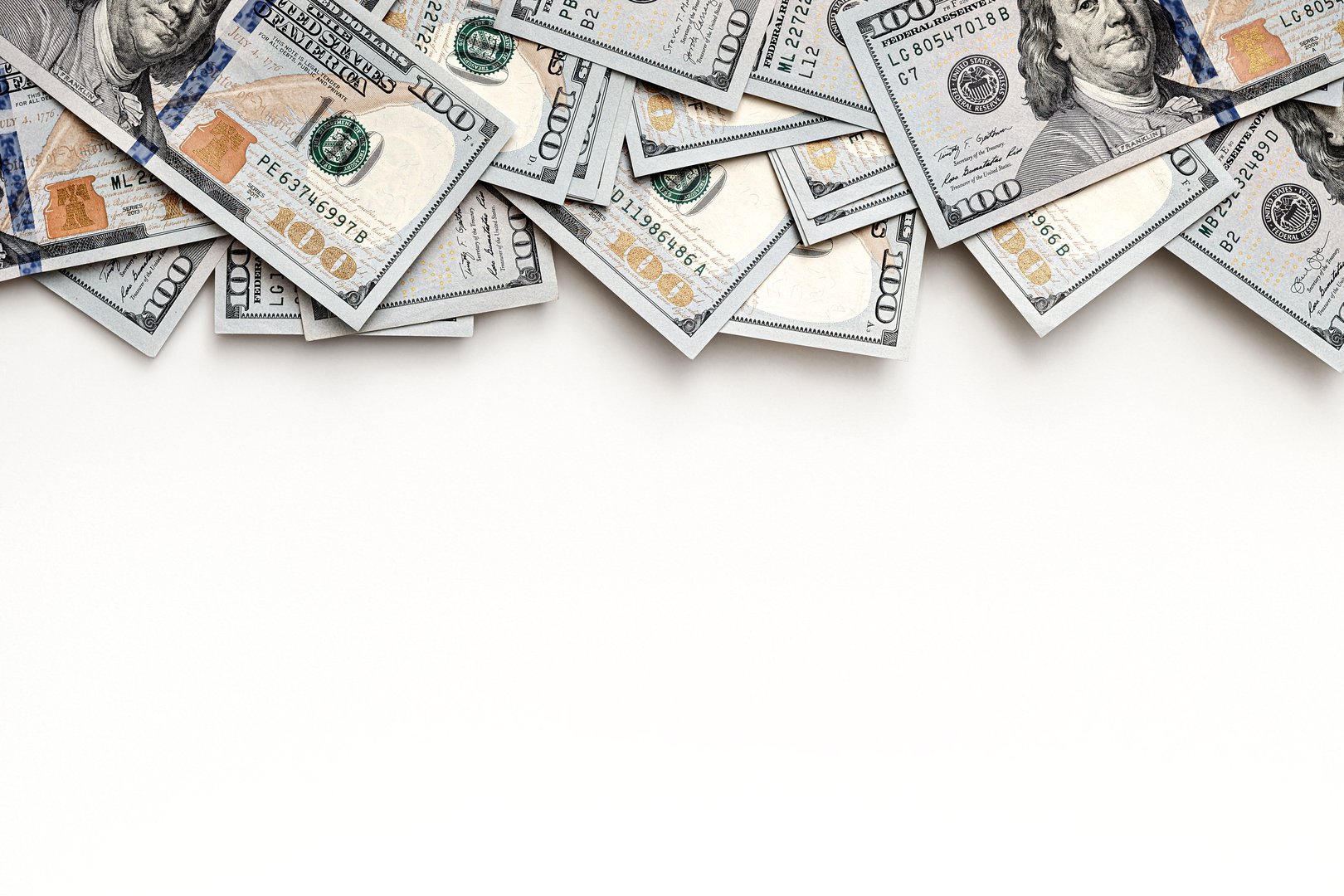 US paper currency with close-up details of one hundred dollar bills. Top view layout with negative space for financial concepts. Banknotes positioned at the top, leaving room for text.