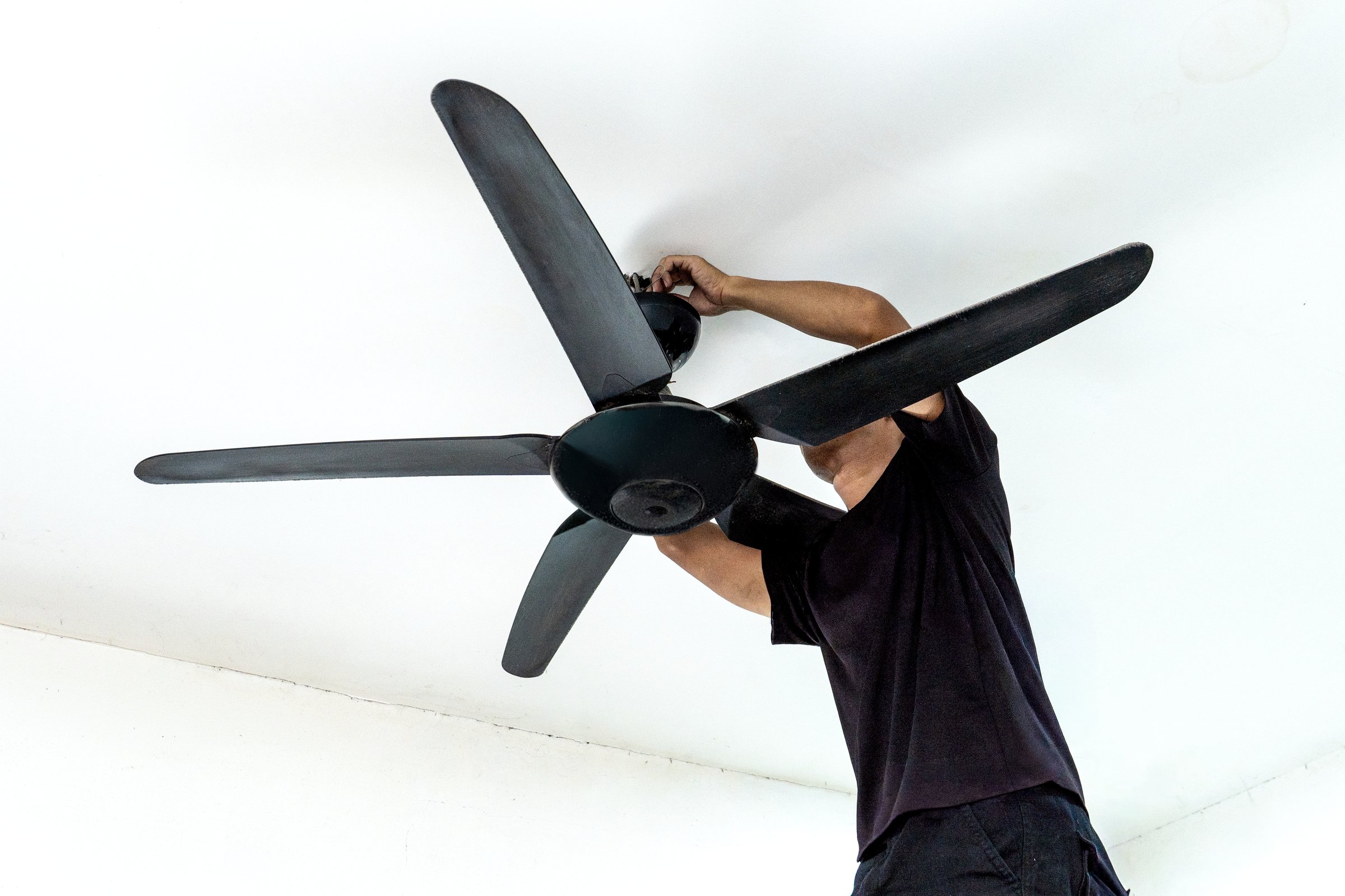 A man installing a ceiling fan. Home improvement, professional work, and technical skill concept.