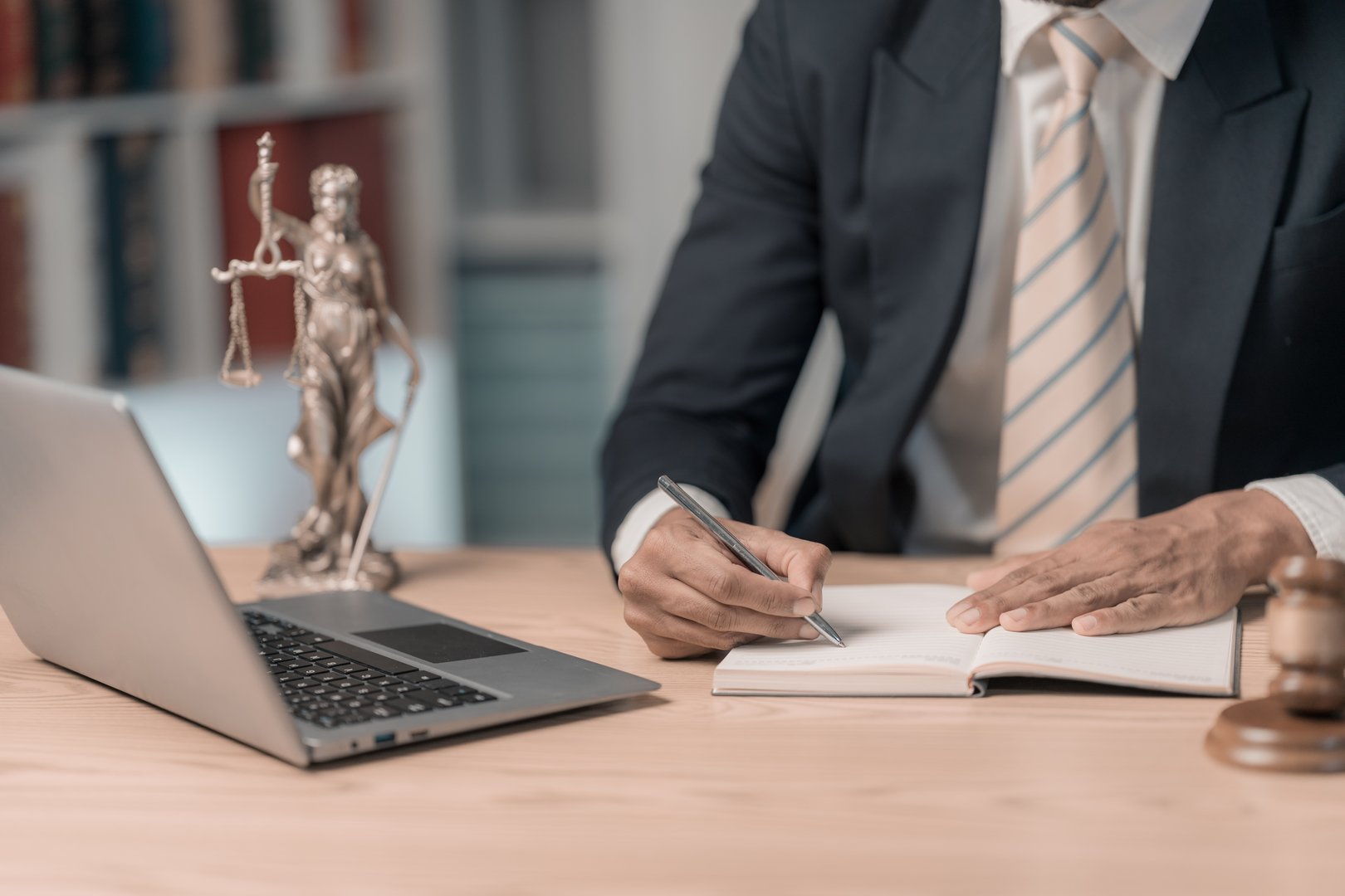 Lawyers working with documents Law, advice and justice concept, lawyer in suit signing legal document at table with justice scale, close-up