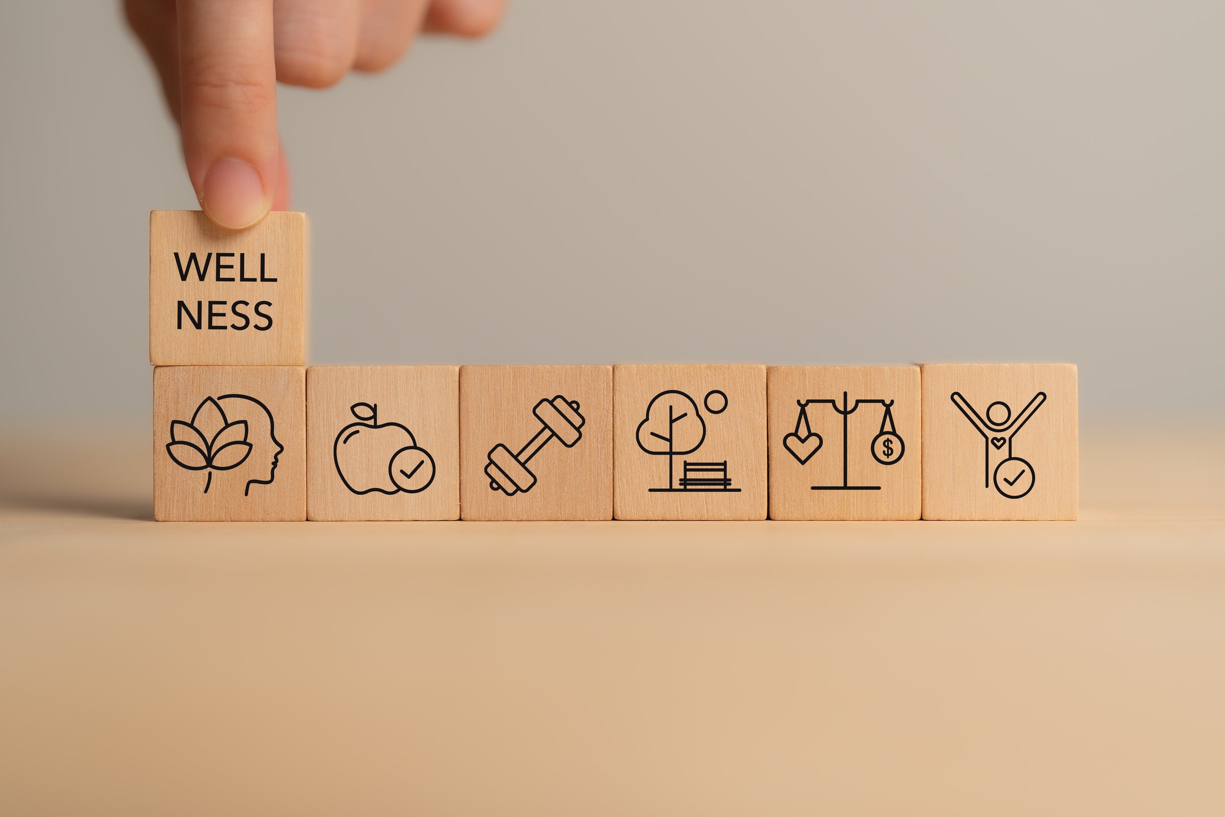 Holistic Wellness Concept. Wooden block with wellness icons, health care ,including mental well-being, fitness, nutrition, sleep, relationships and financial balance. Personal development and balance.