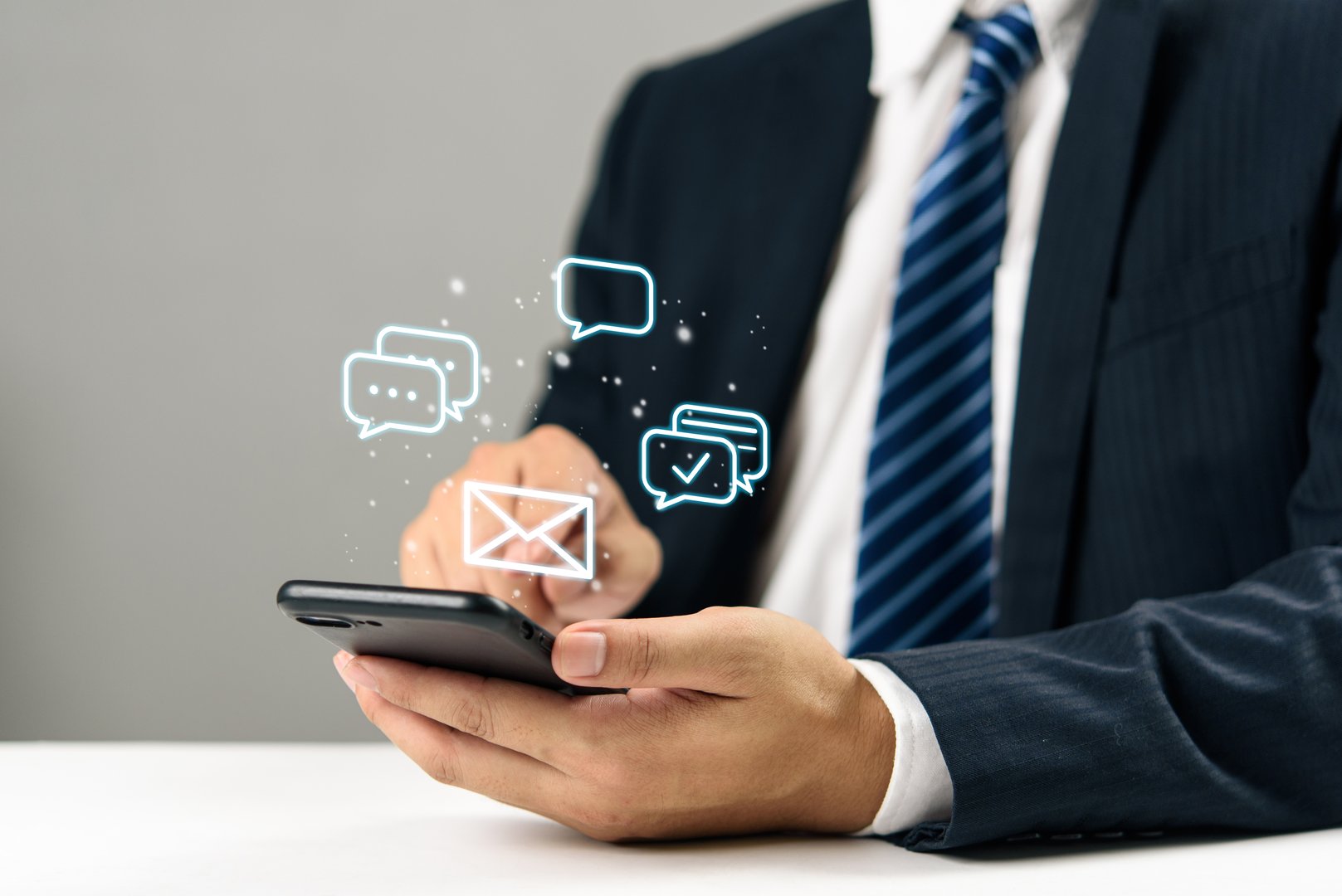 Businessman hand holding smartphone with digital chat and email icons, communication online messaging, social media, mobile marketing, and modern customer engagement technology.