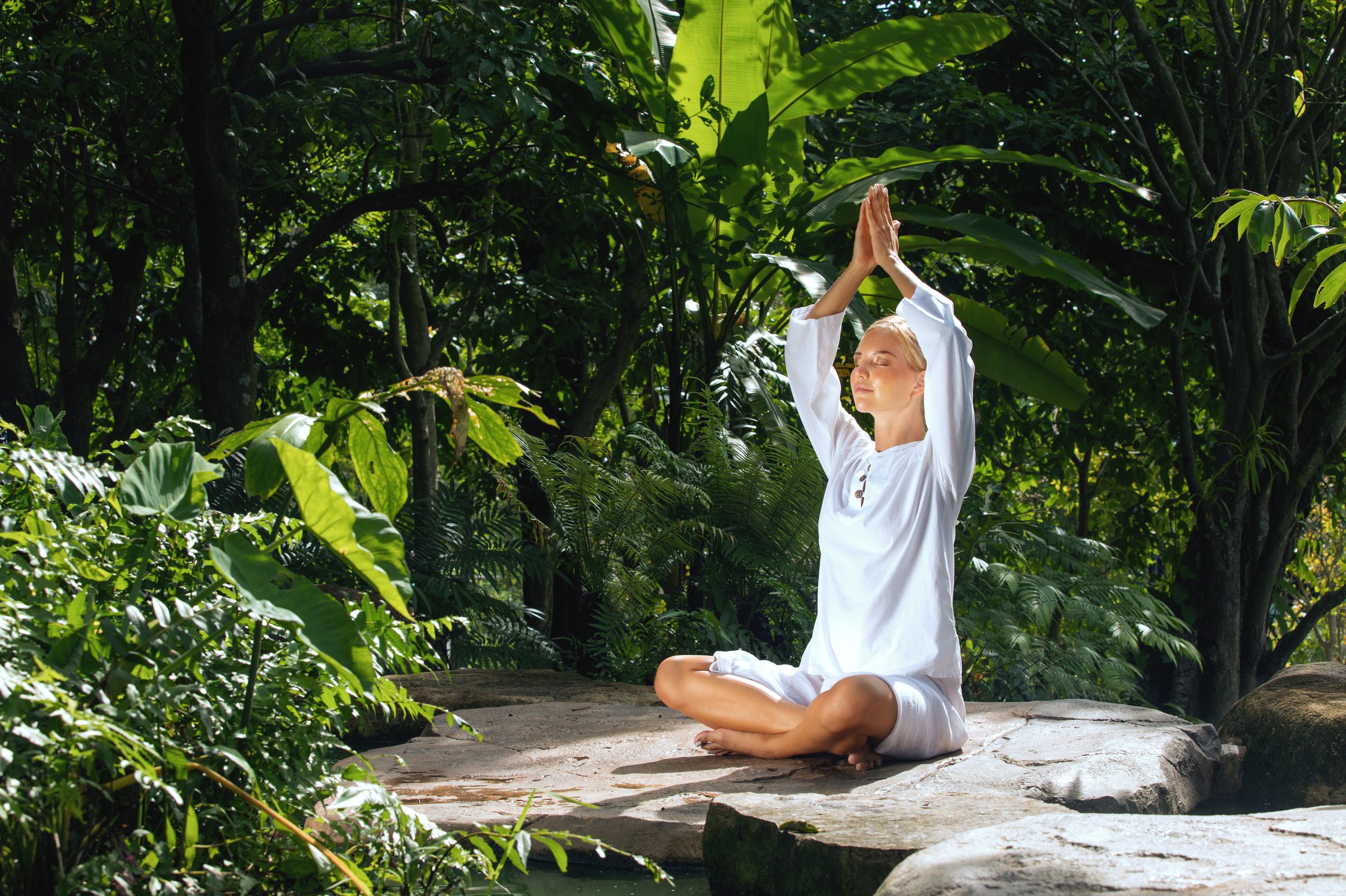 Portrait of young woman practicing yoga in tropic environment