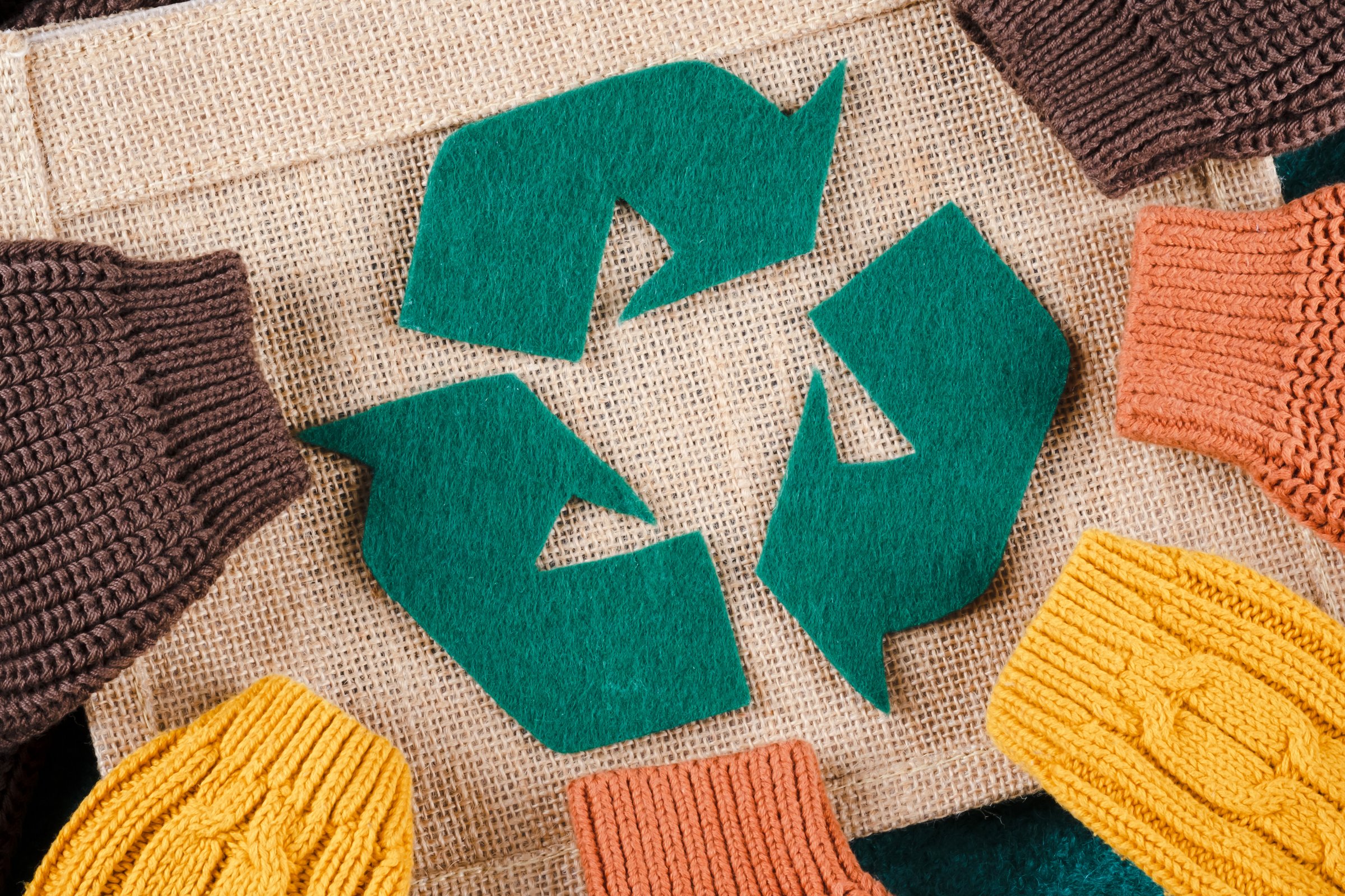 Green recycling sign on a shopping bag with sleeves. Used clothing. Conscious by the consumer. Protect nature and save planet.