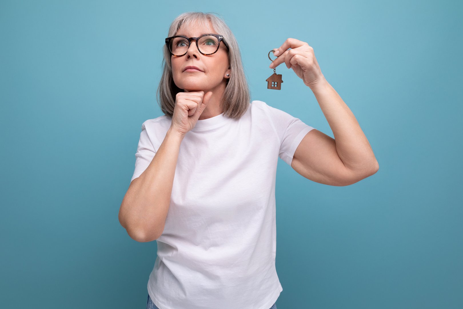 middle-aged turnkey business. mature woman holding real estate keys.