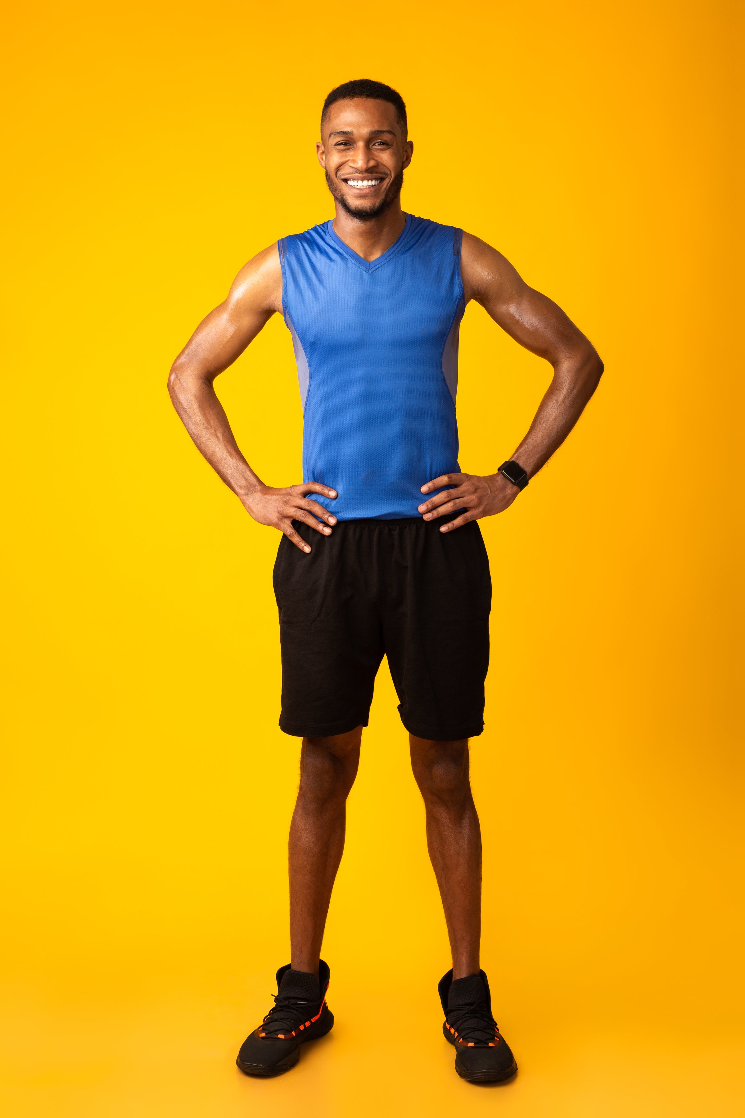 Full Length Happy Afro Sportsman Smiling At Camera Isolated Over Yellow Studio Background, Copyspace, Vertical