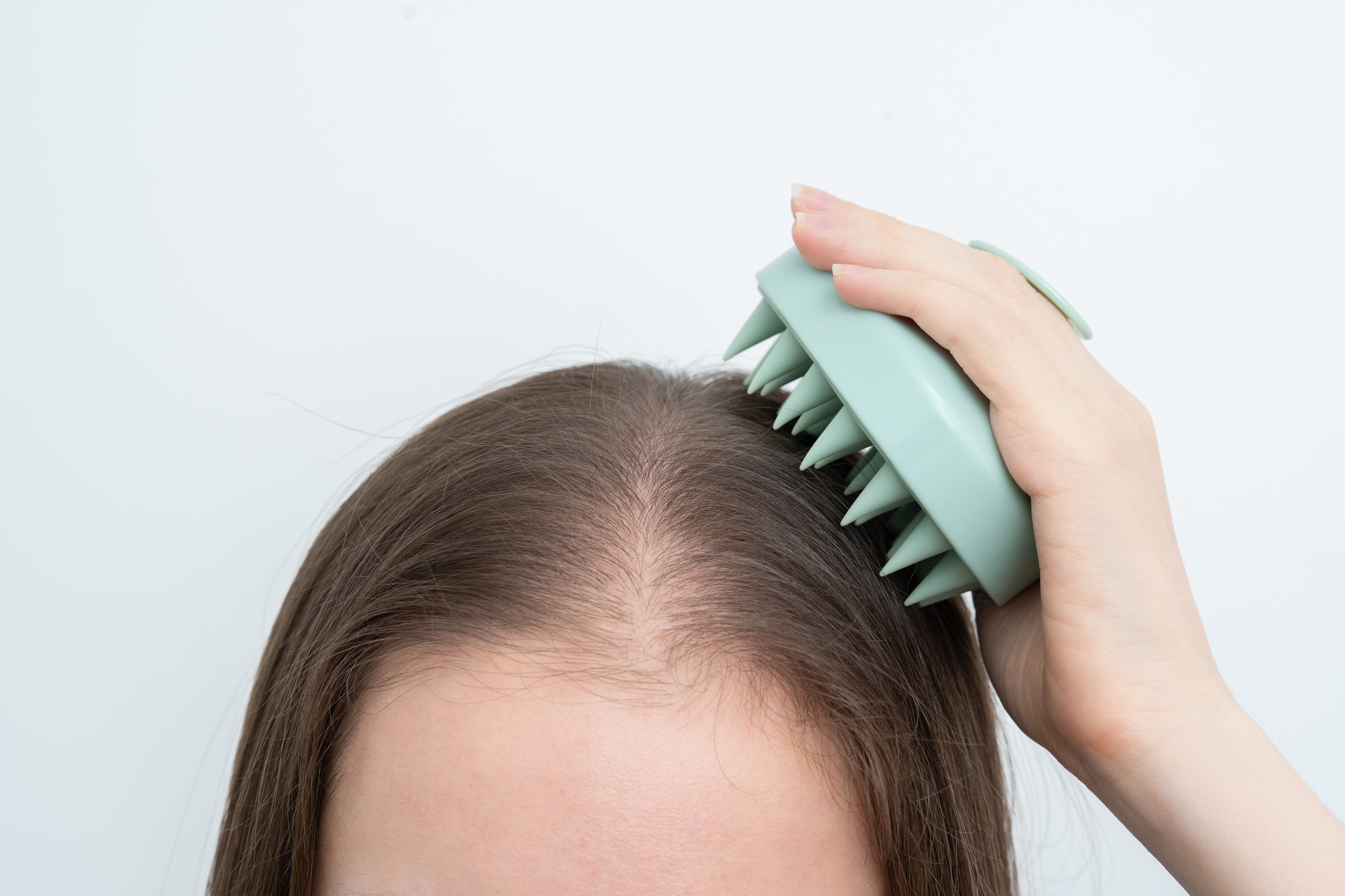 Woman receiving scalp micropigmentation treatment in Bradenton FL - female SMP procedure session at CC Styling Studio professional salon