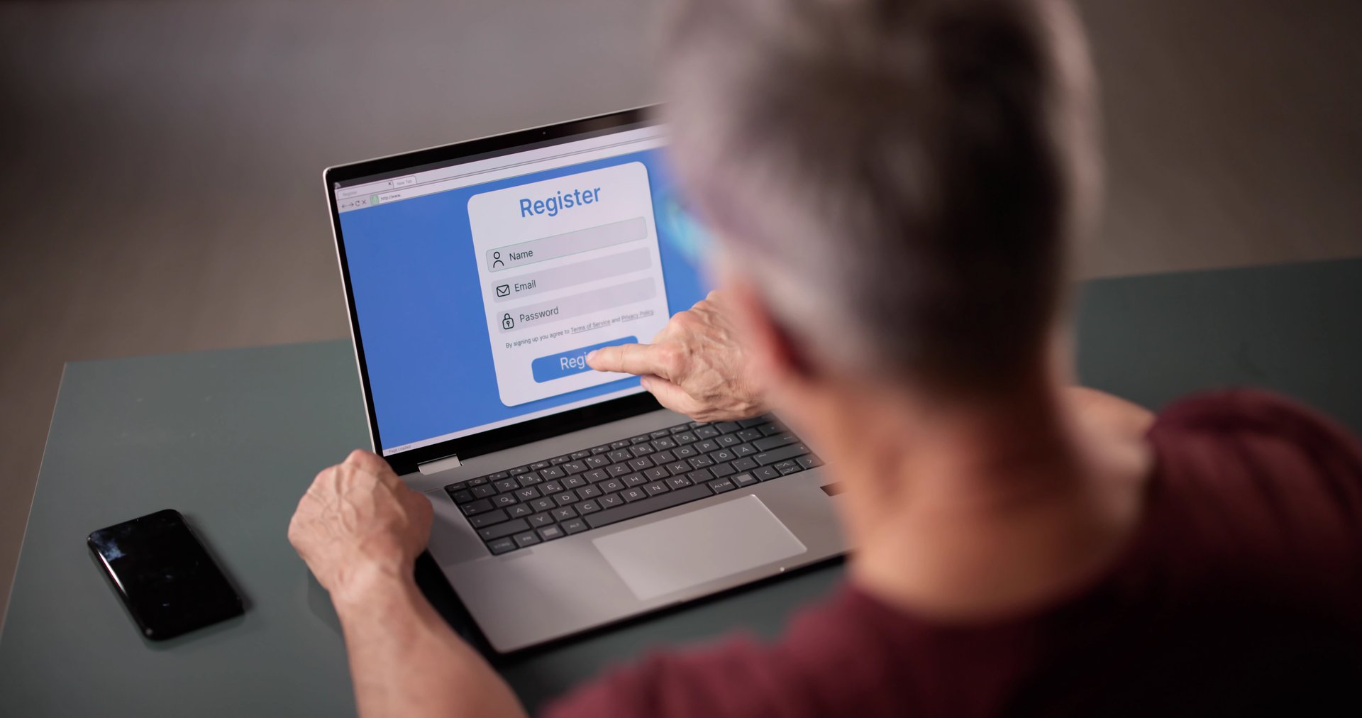 Businessman's Hand Filling Online Registration Form On Laptop