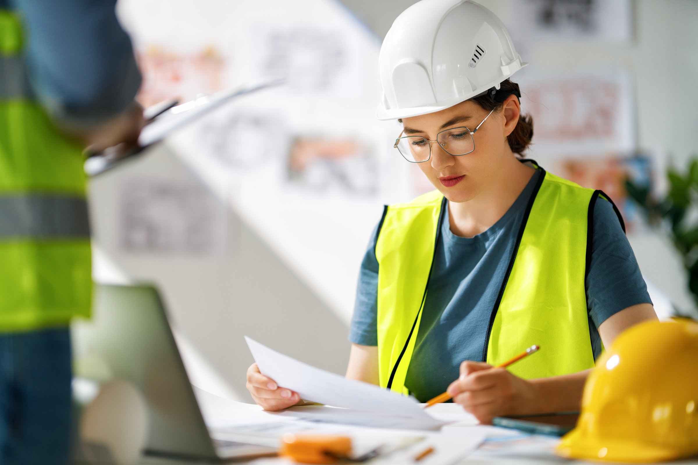 Team of architects working on plans at construction site.