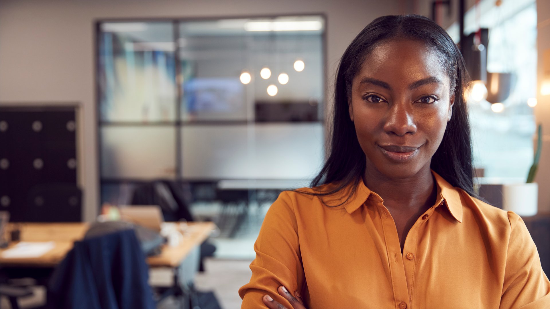 Head And Shoulders Portrait Of Smiling Young Businesswoman  Working In Modern Office