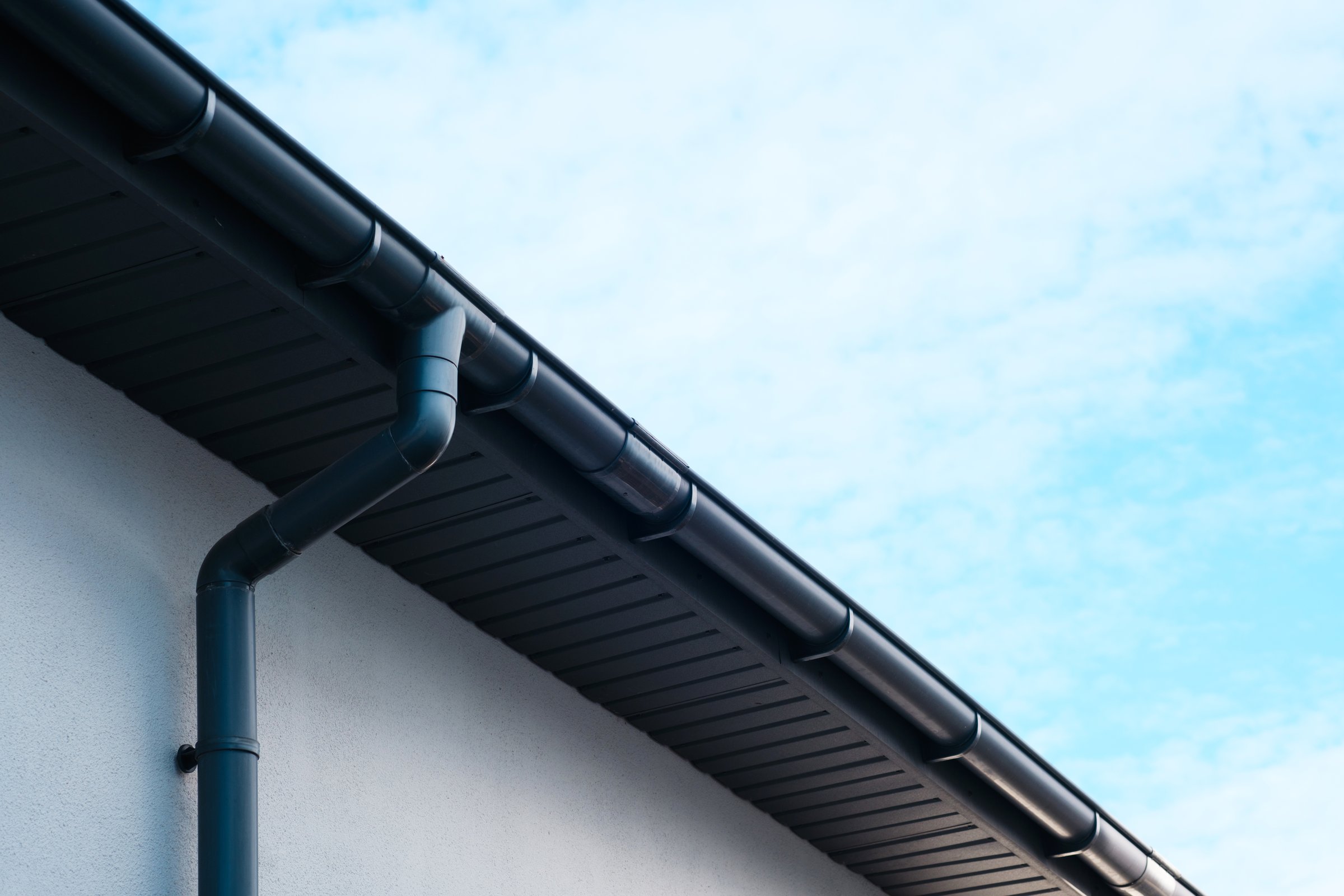 The structure features a sleek gutter along the edge with clouds above.