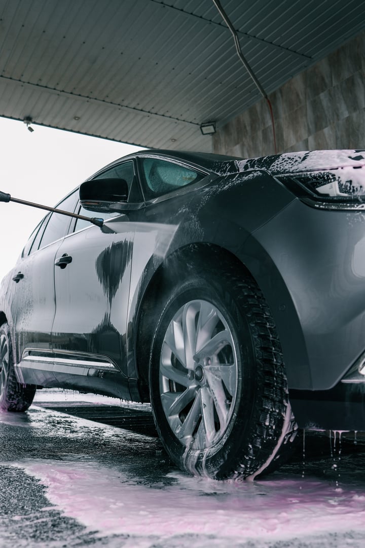 Hand washing car with pink foam, advertising.
