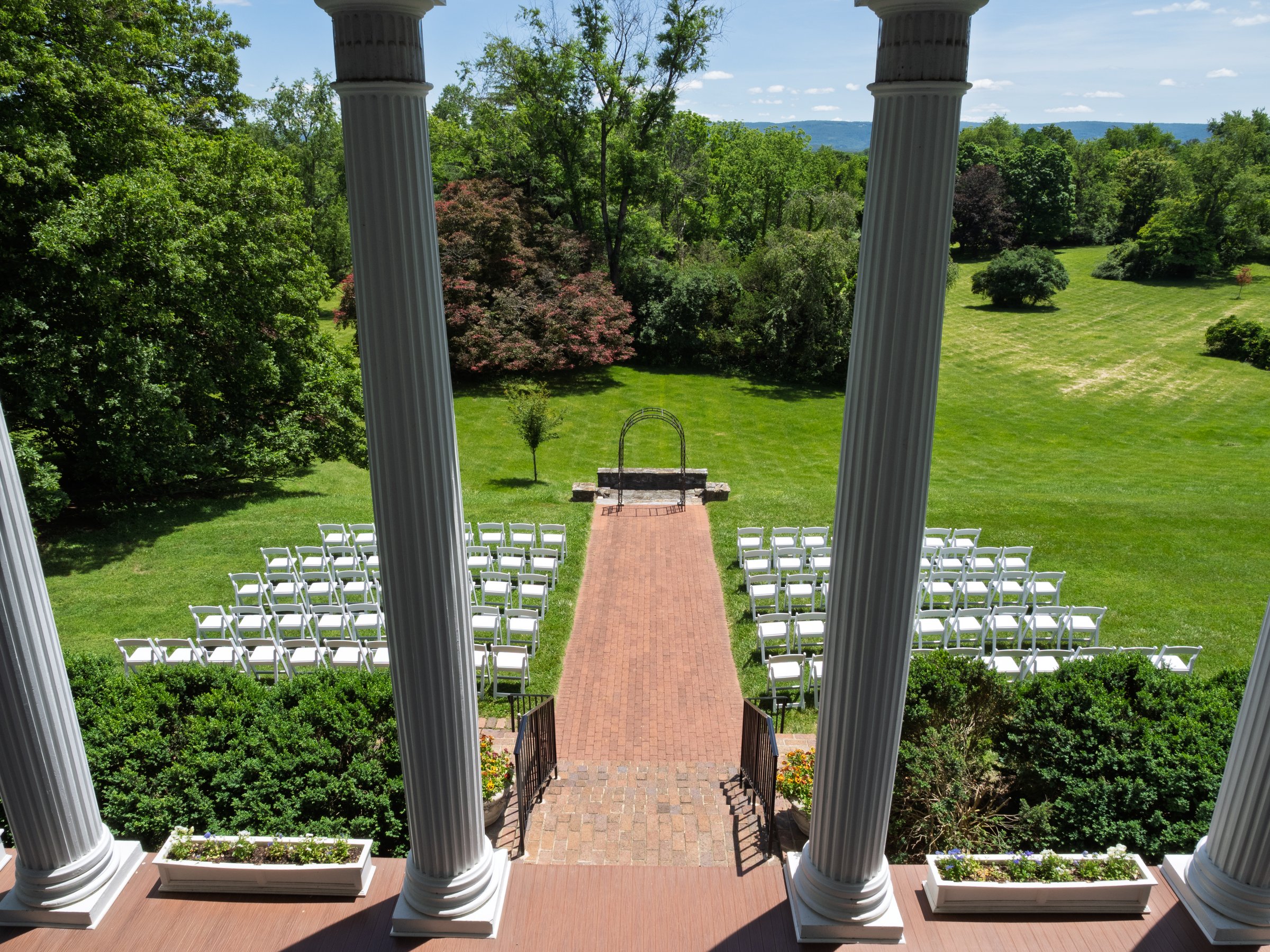 Elegant outdoor wedding ceremony setup with white chairs and aisle on the sprawling lawn of Historic Rosemont, Berryville, Virginia.