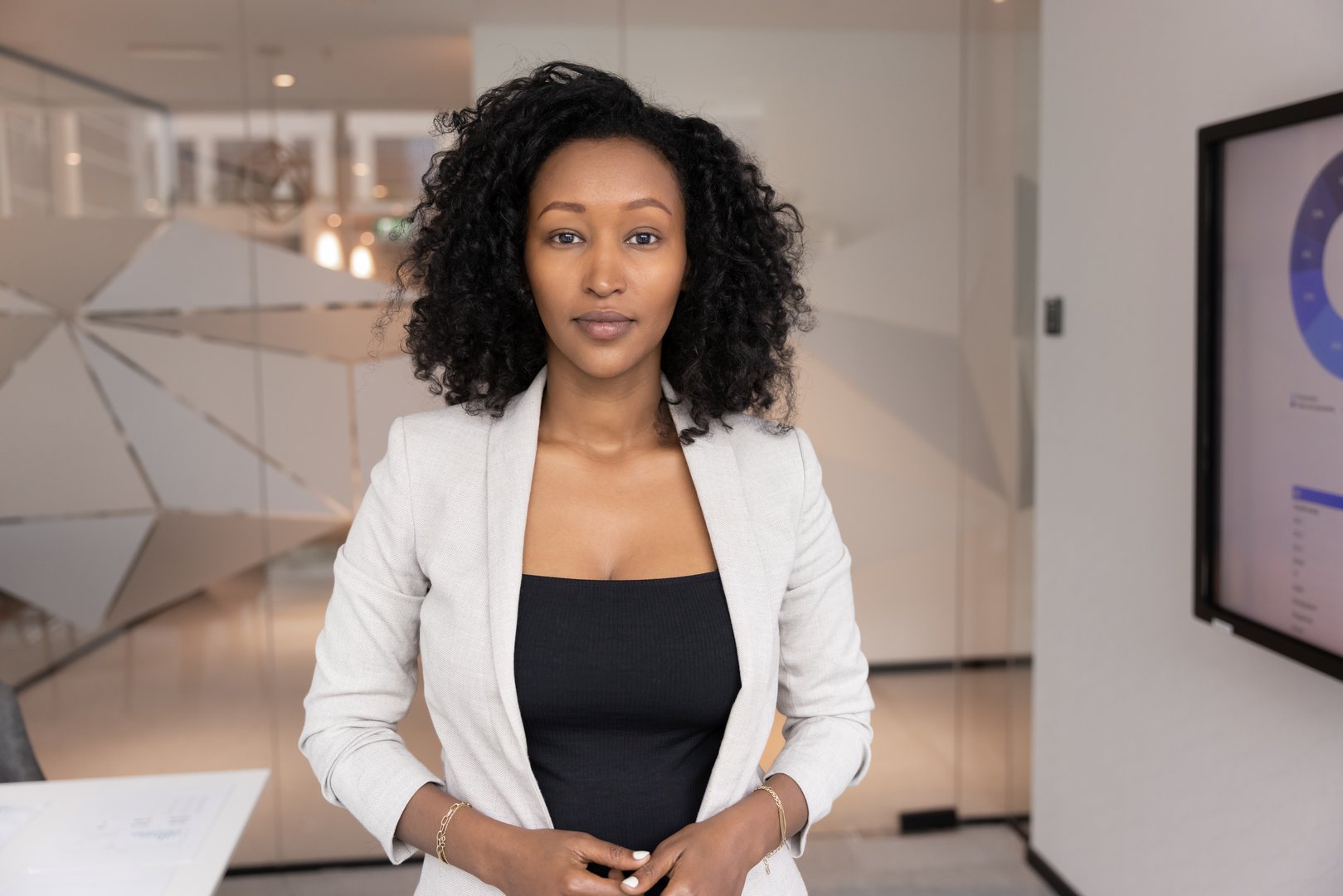 Portrait of African professional businesswoman stands confidently in modern meeting room, look at camera with serious, focused expression. Data analysis, business strategy, and corporate leadership