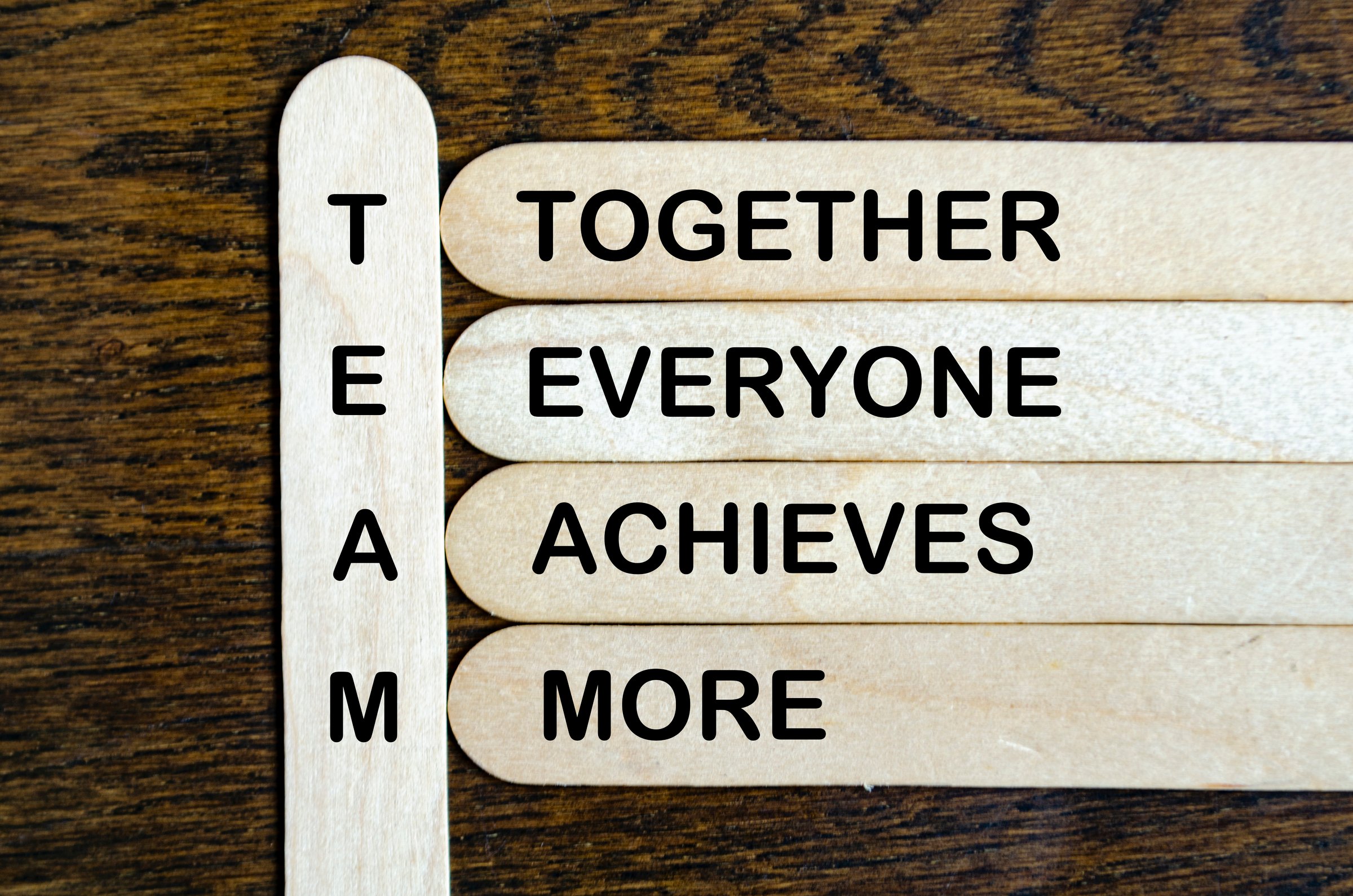 TEAM representing Together Everyone Achieves More text on wooden stick