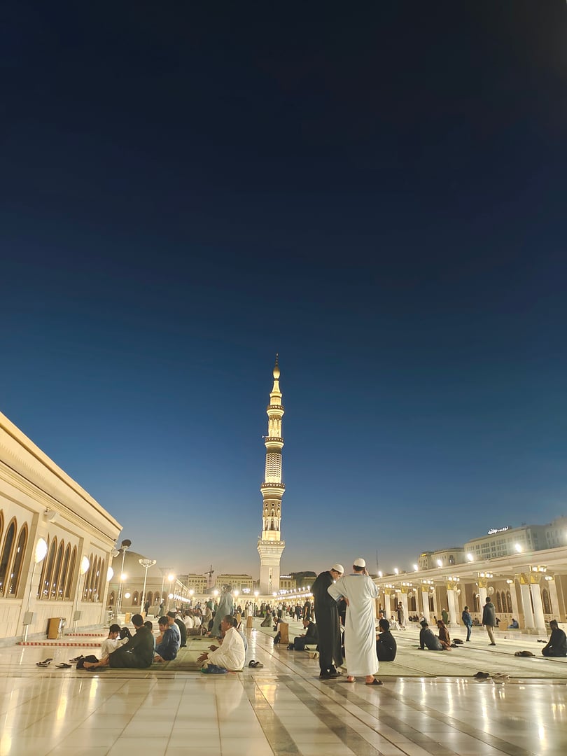 The image describes the atmosphere on the rooftop of the Nabawi Mosque before the Maghrib prayer