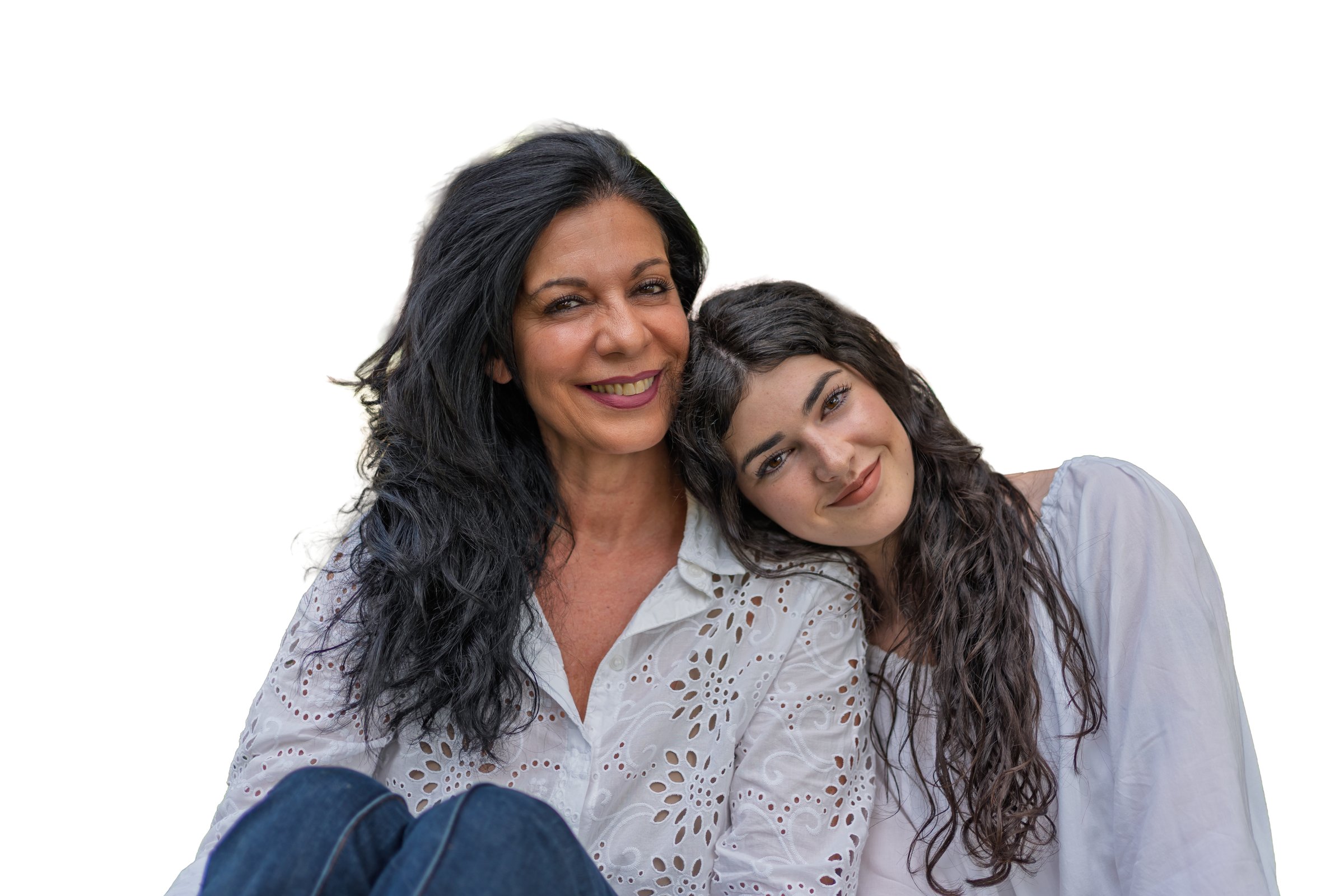 Mother and adult daughter embrace and smile at the camera, radiating warmth, affection and strong family bond on a clean white studio background