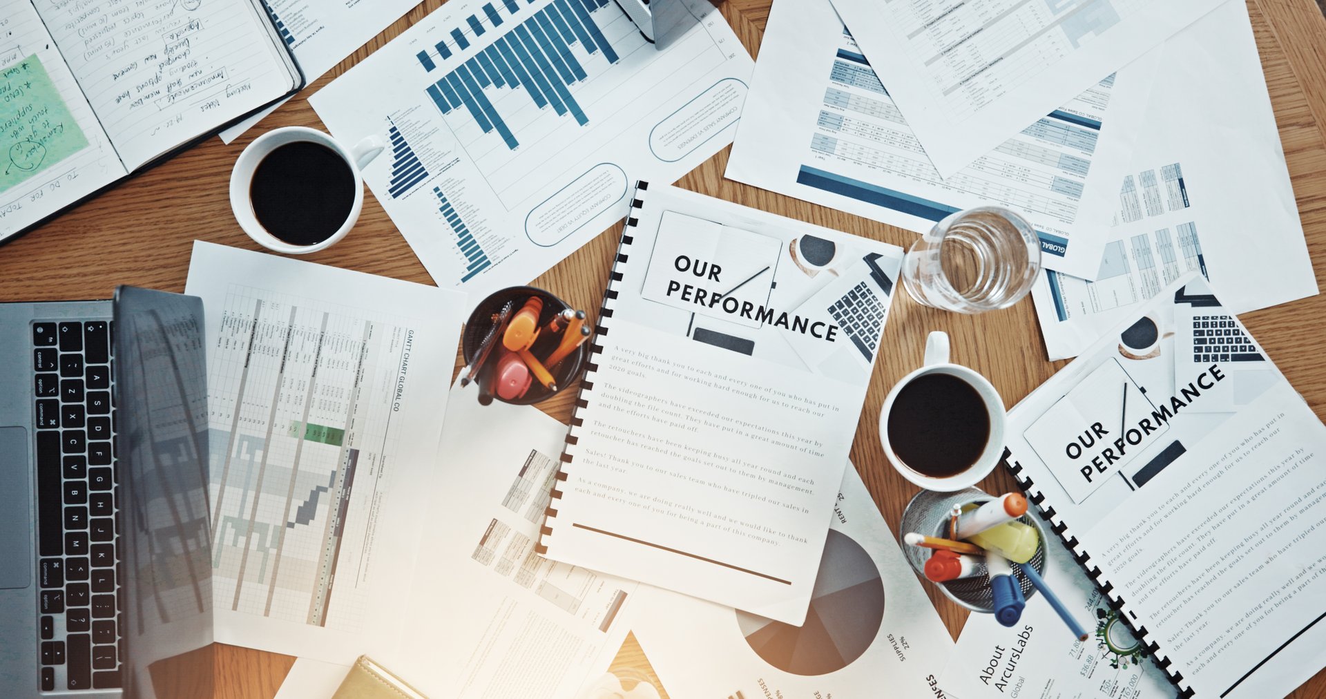 Documents, research and planning with desk in office for expenditure report, budget and chart. Performance, project capital and revenue paperwork with above of folder for audit invoice and funding