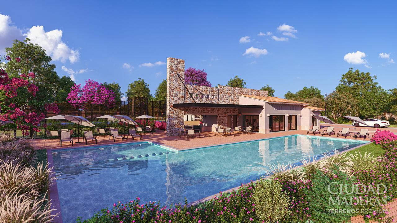 Modern clubhouse with a swimming pool, surrounded by lush greenery and blooming flowers under a clear blue sky.