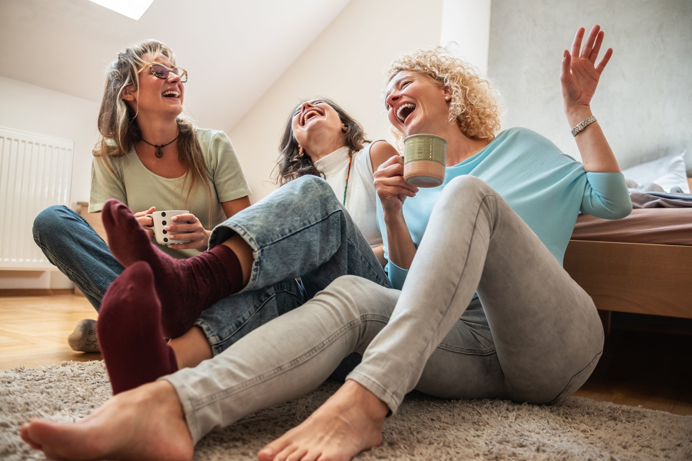 A modern mother enjoys a coffee while spending time with her two daughters. They sit together at a cozy café, talking and sharing laughter.