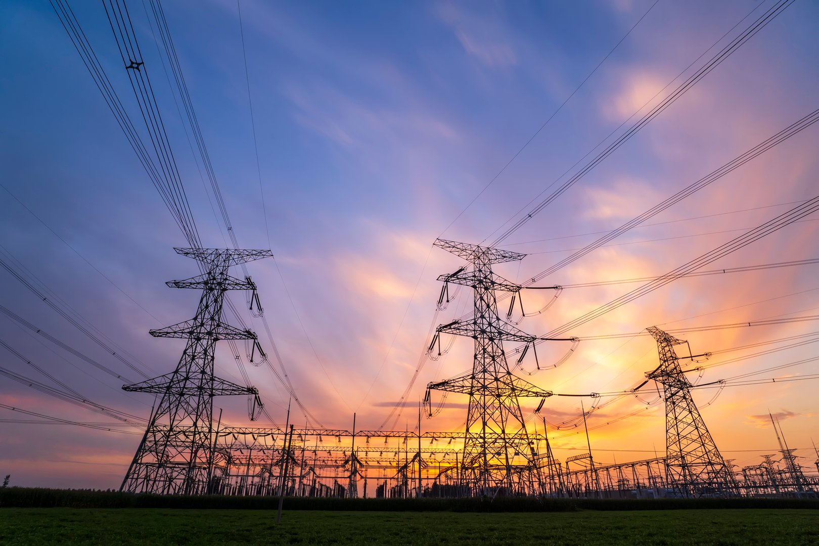 Silhouettes of pylons, substations and high-voltage pylons in the evening