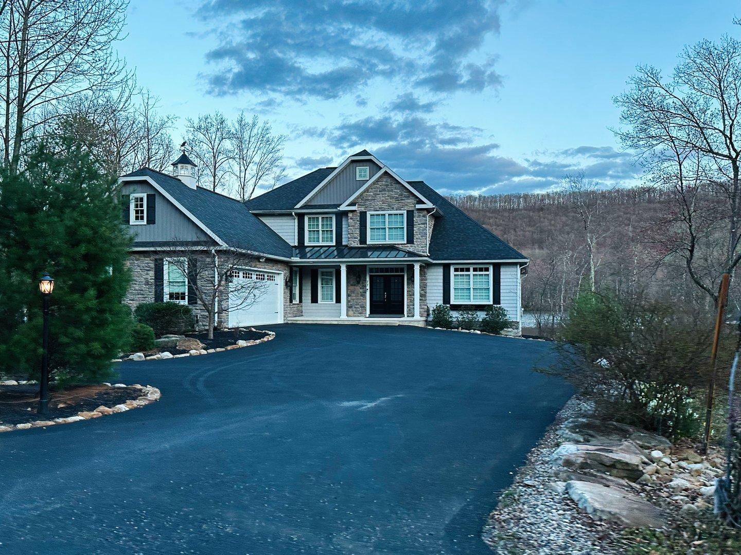 Jenkintown, Pennsylvania, USA - April 01, 2025: Elegant modern home nestled among lush trees in Pennsylvania during serene evening lighting