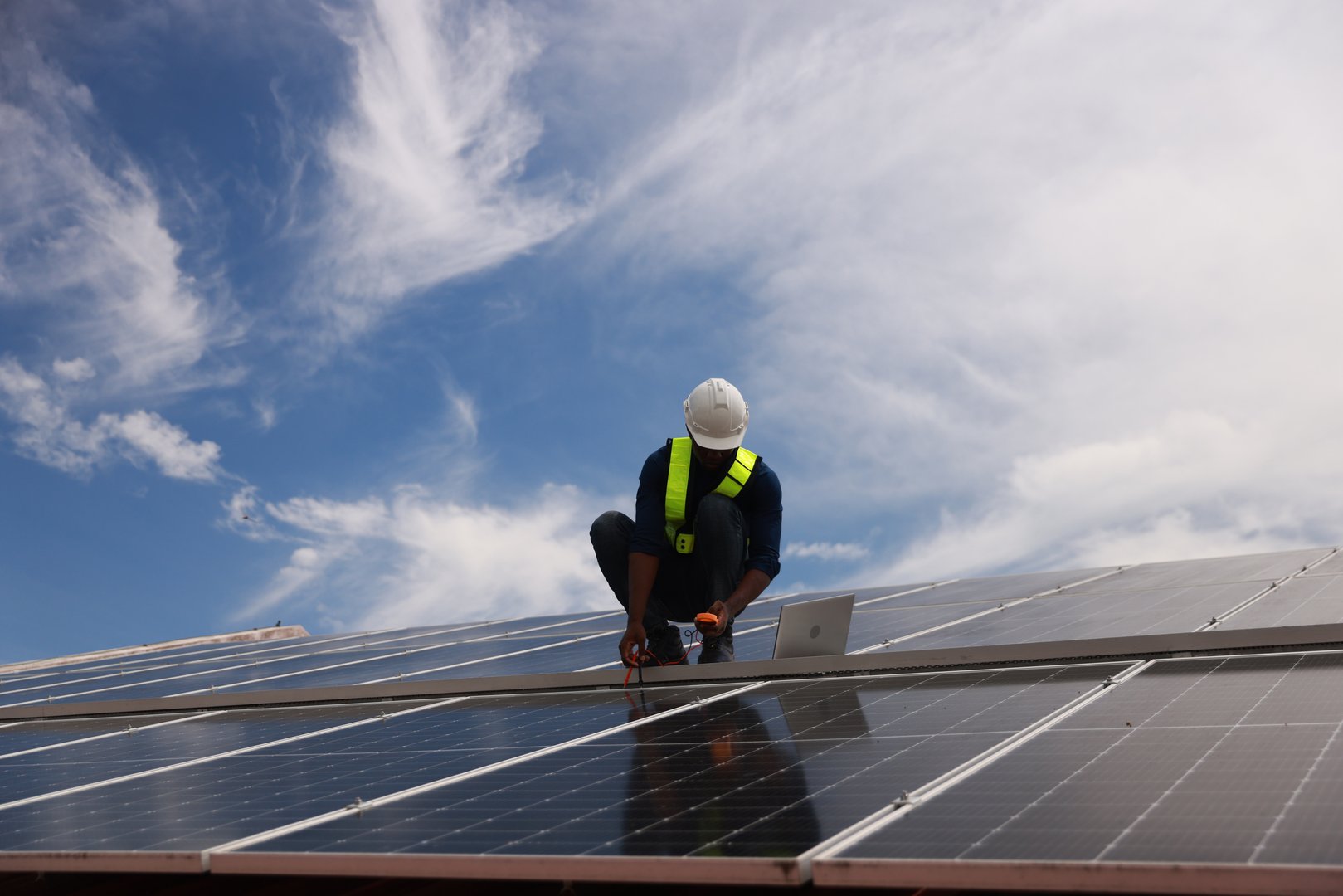The black male Solar energy systems engineer performs analysis of solar panels  at the solar farm