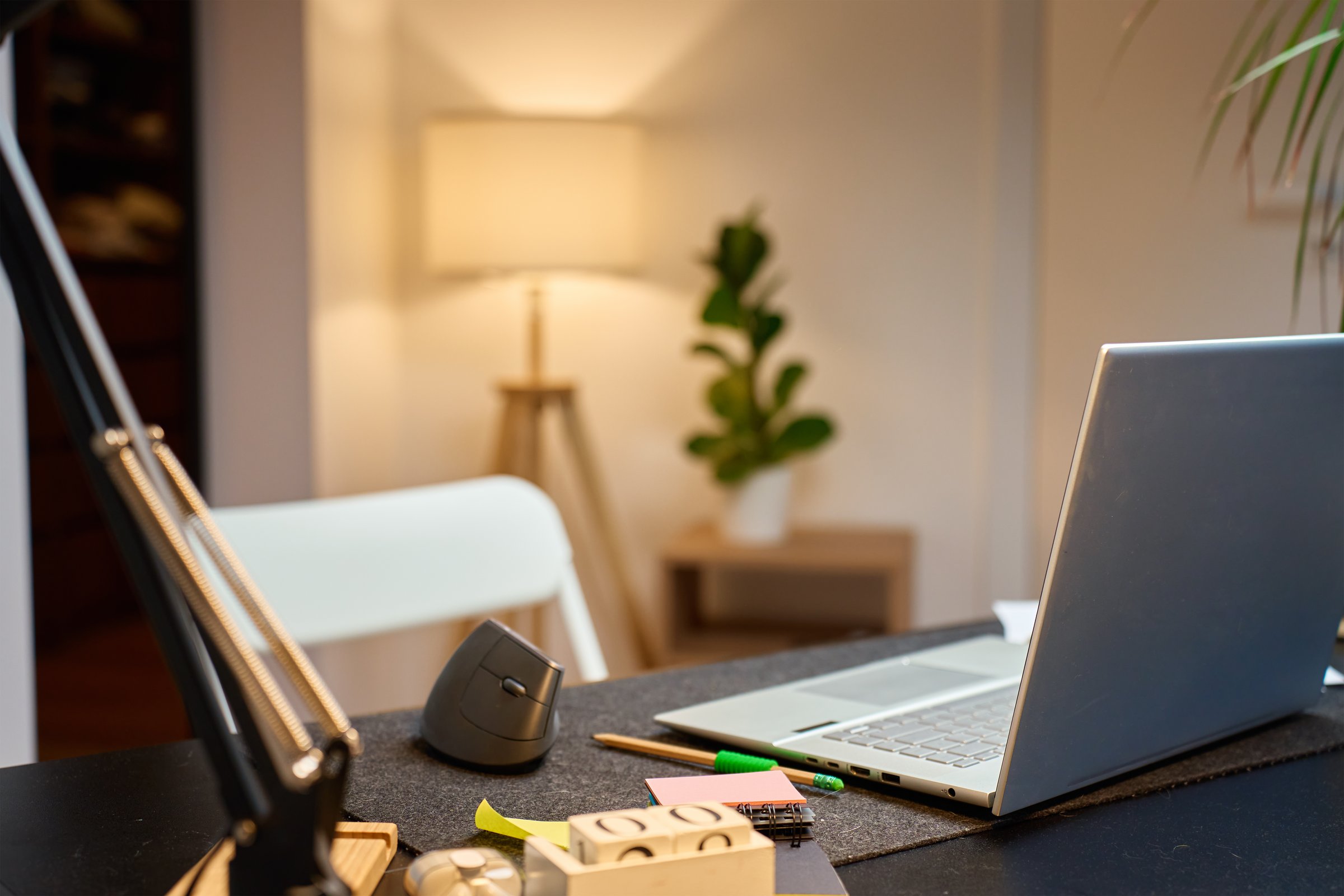 Home office desk with laptop, ergonomic mouse and stationery items. Remote work, productivity and modern home office setup