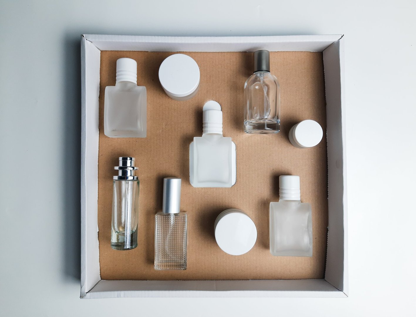 Glass perfume bottles and round jar in a box package