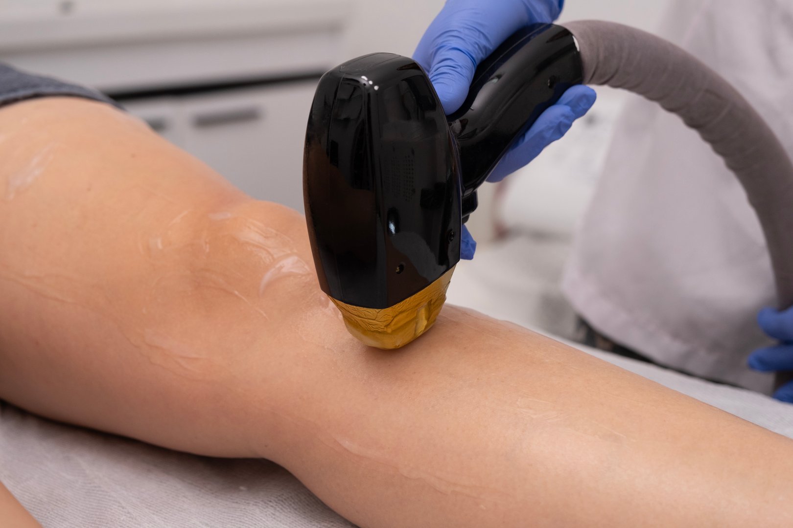 Laser epilation - hair removal procedure. Flash of diode laser hair removal, Beautician removes hair on beautiful female legs, Hair removal for smooth skin, laser procedure at beauty studio or clinic.