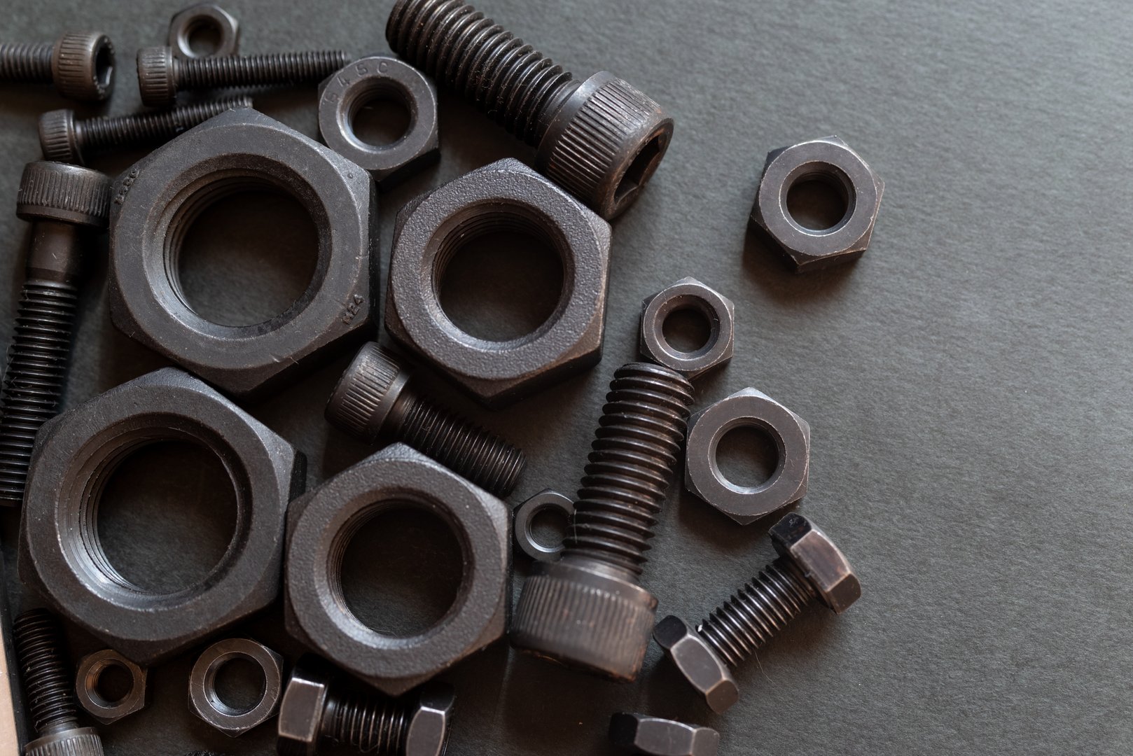 Multiple hex nuts lined up on a black background