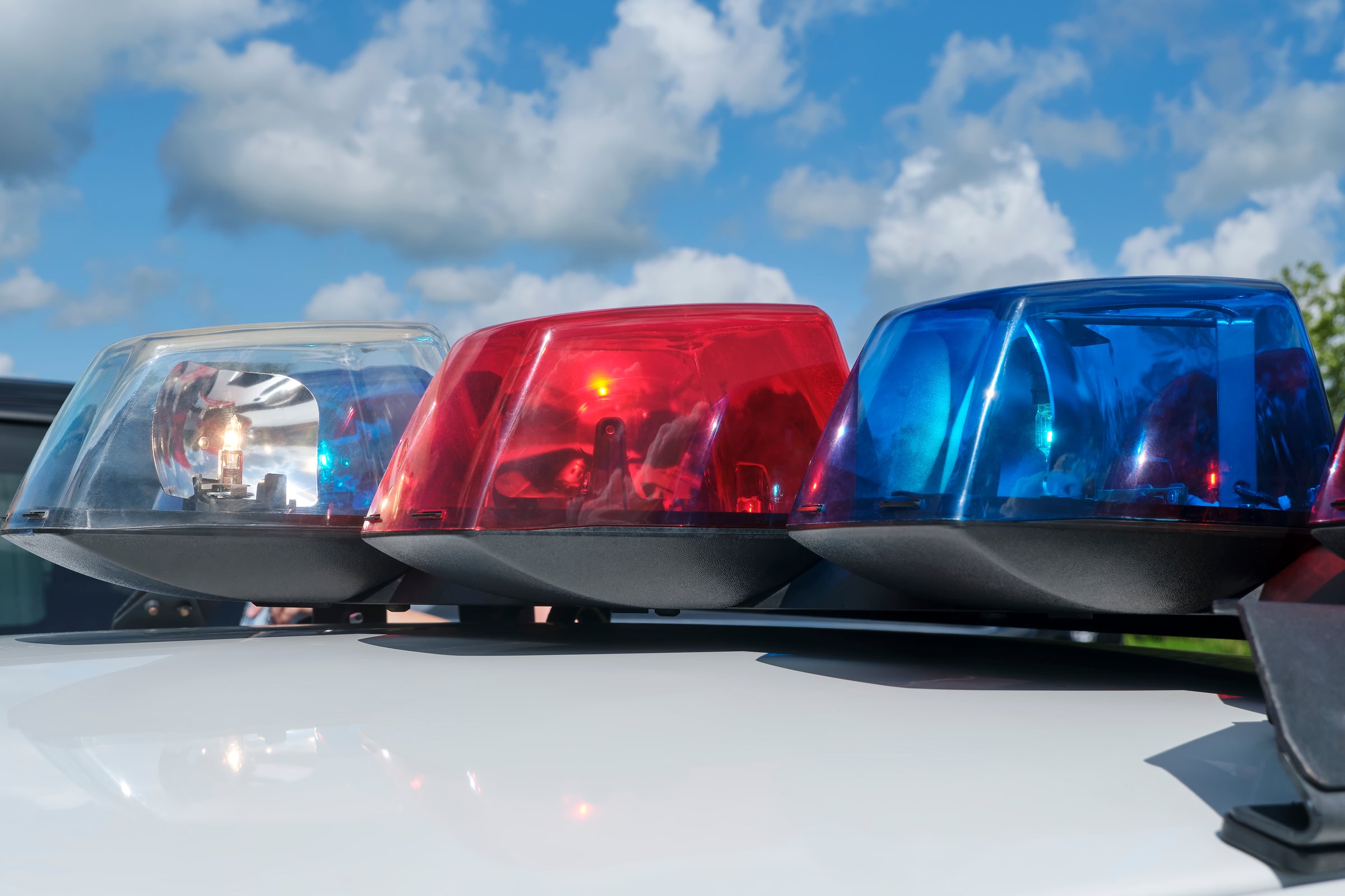 Closeup of red, white and blue emergency or police car siren flashing lights on a police automobile