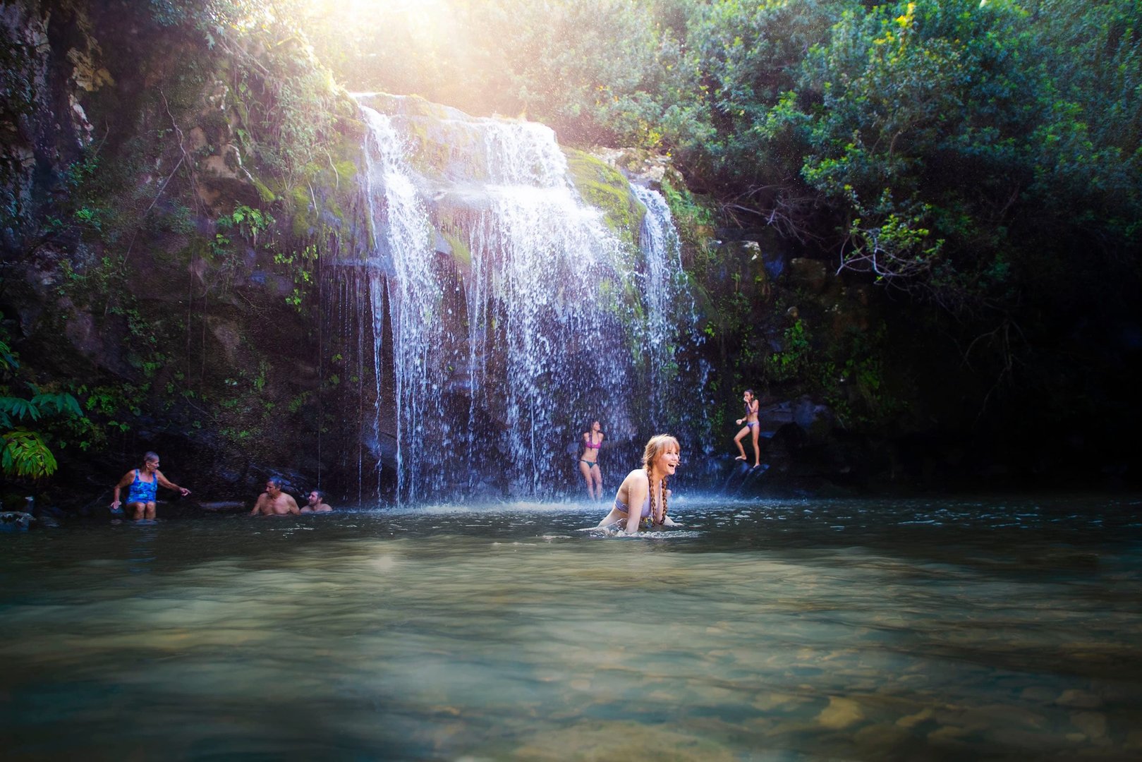 Spectacular waterfall cascading down lush tropical cliffs surrounded by verdant rainforest vegetation