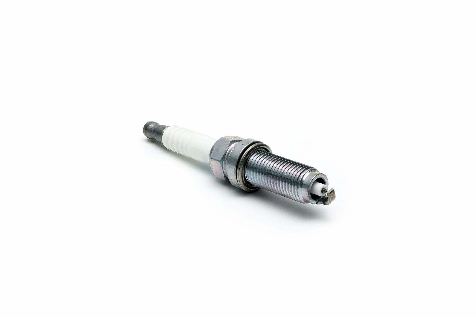 New spark plug on white background, isolated.Car part. Spark plugs isolated on white.