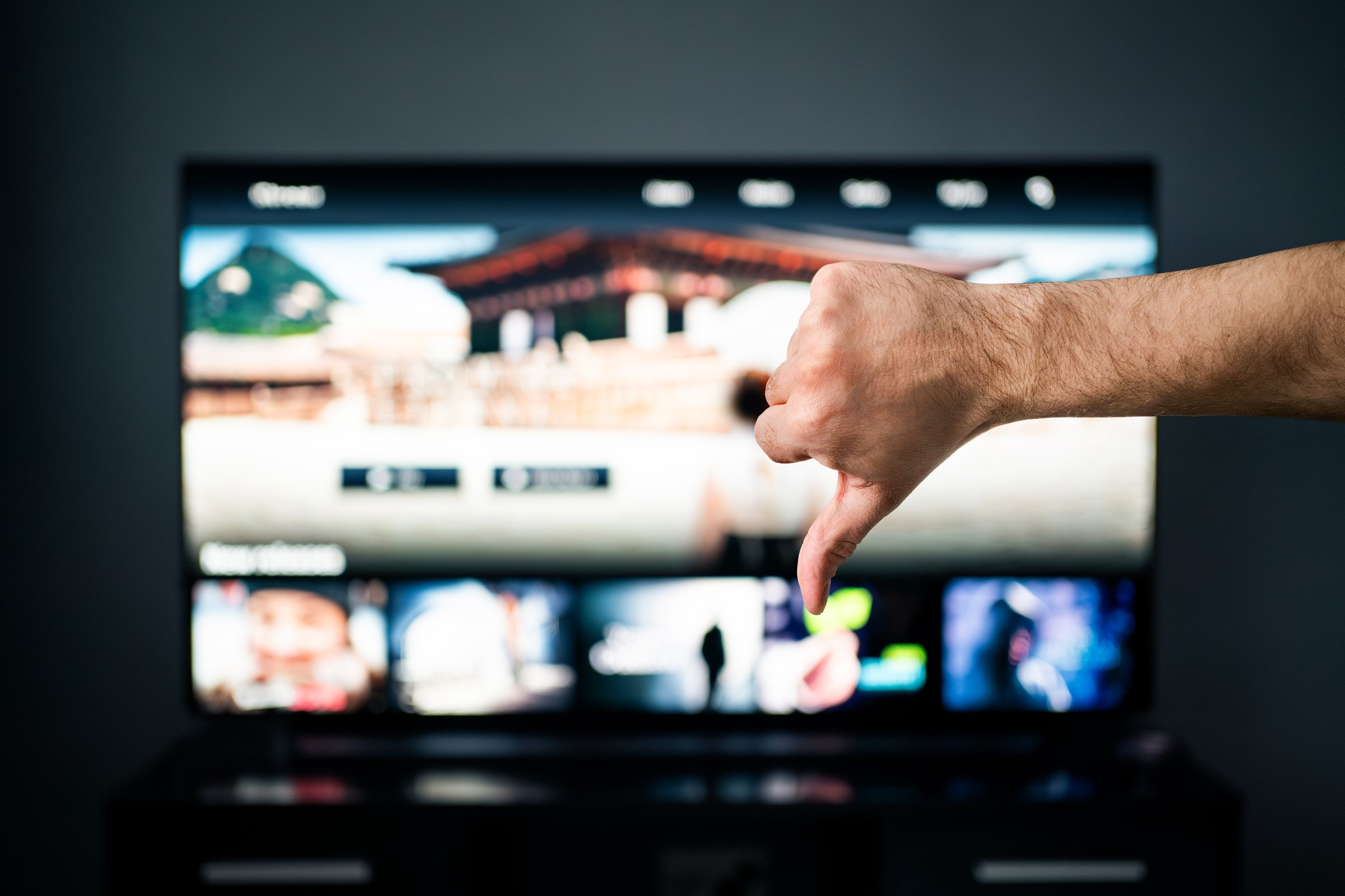 Bad movie stream service on tv. Thumbs down, dislike. Video on demand, VOD. Cancel subscription. Negative feedback. Series and film site online with expensive price. Watching television. Slow internet