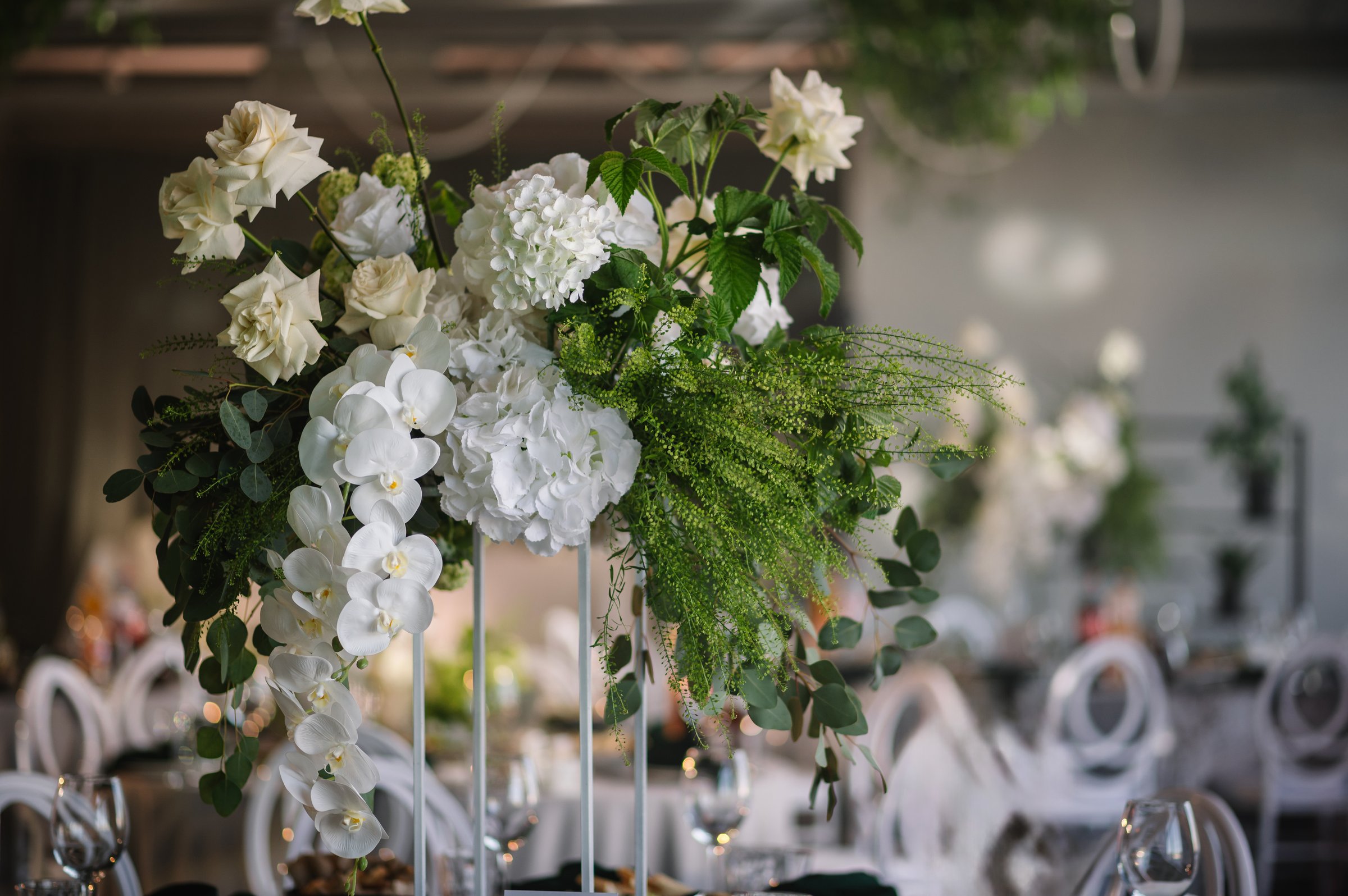 Flowers decor on the table closeup. Wedding set up, dinner table reception in a restaurant. Serving, setting table in hall. Glass, luxury rich decor. Birthday, baptism, event.