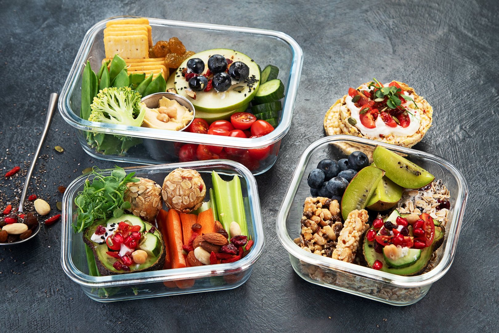 Lunchboxes with various healthy nutritious meals. Concept of healthy snacks in boxes on a dark background. Top view.