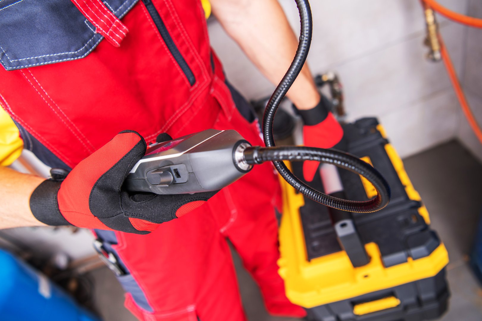 Closeup of Professional Plumber with Portable Gas Leak Detector in His Hand Checking the Efficiency of the Water Heating System