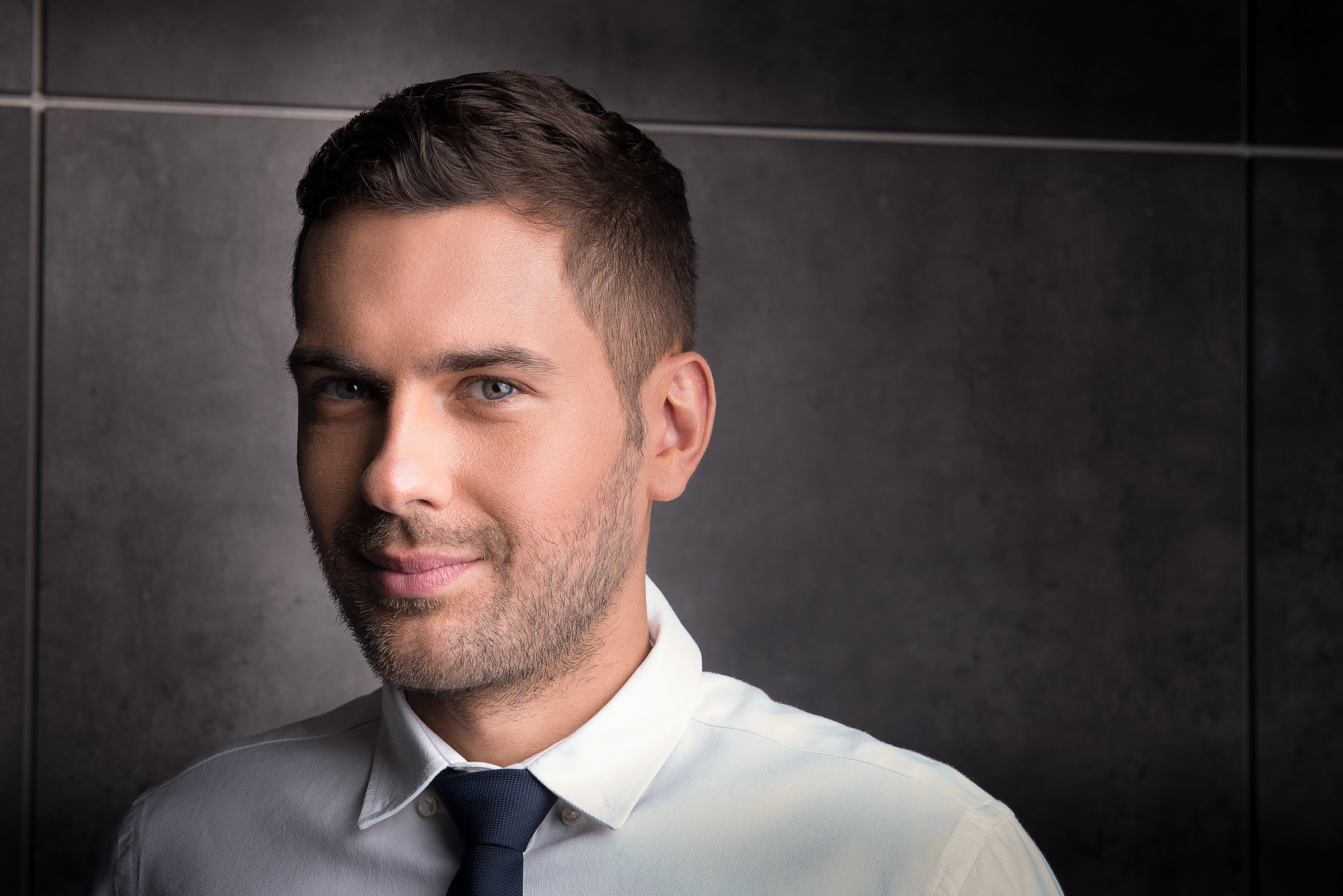 Follow your dreams. Portrait of interested young wealthy guy looking at camera charmingly. Copy space in the right side