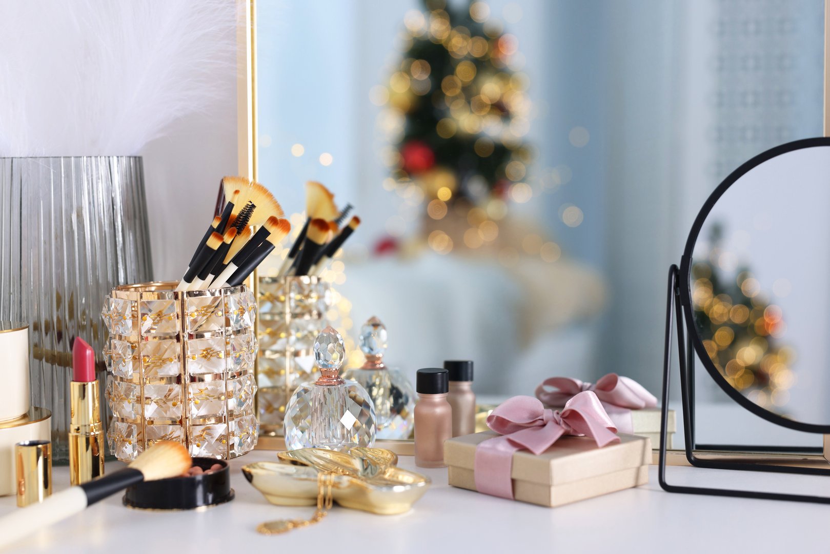 Makeup brushes, cosmetics, mirror and perfume on white table indoors