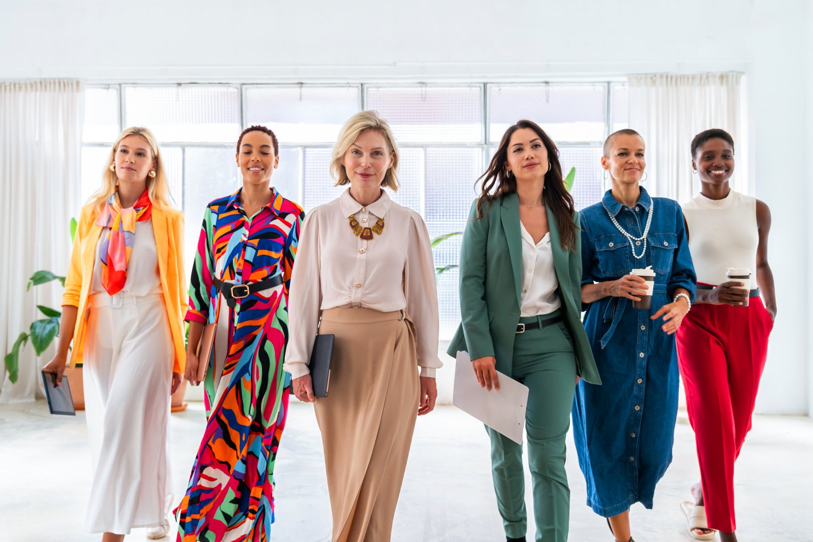 Group of beautiful confident businesswomen meeting in the office - Multiethinc female creative team brainstorming at work - Diverse colleagues working together  in workshop  in a co-working space