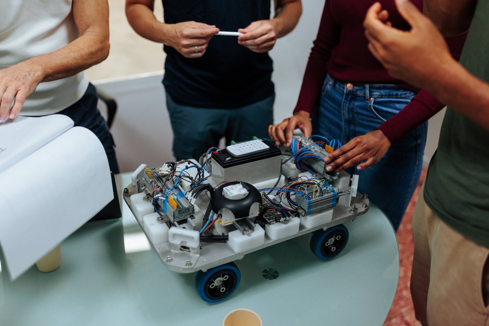 Engineers working together on a robotics project, assembling and testing a robot prototype in a collaborative workspace