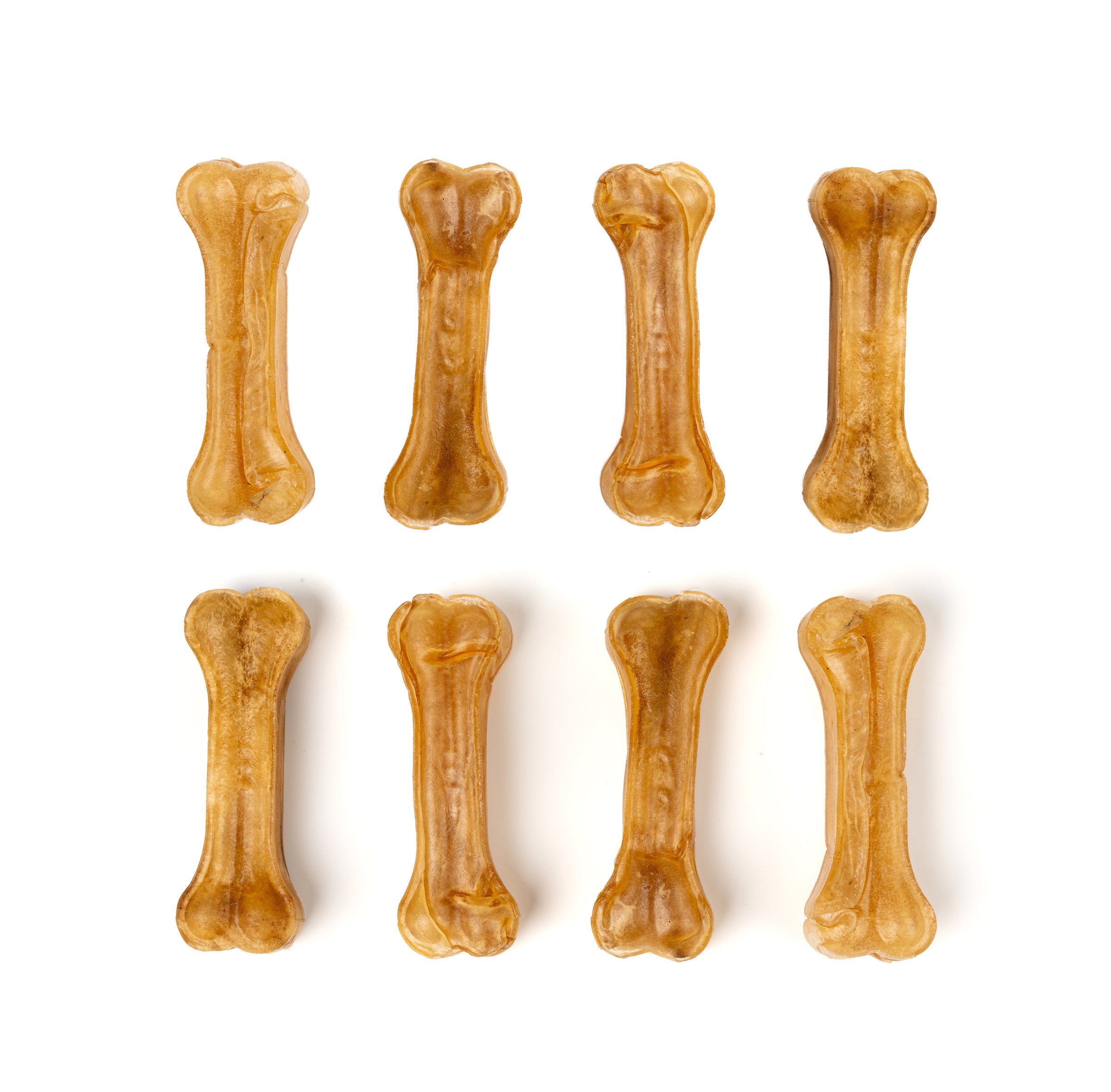 Rawhide bones isolated, collagen dog chew food, pressed dry kibble, natural long-lasting canine dental care treats in bones shape on white background top view