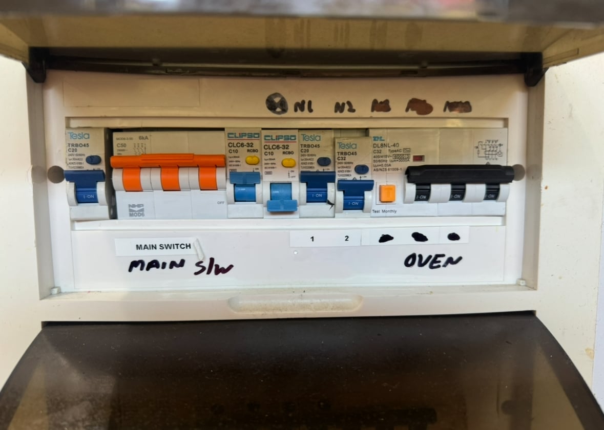 Technician performing RCD safety testing on a distribution board.