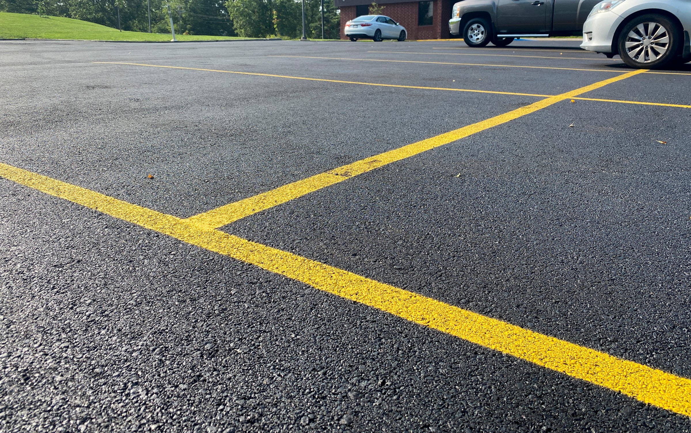 Freshly resurfaced asphalt parking lot with yellow lines